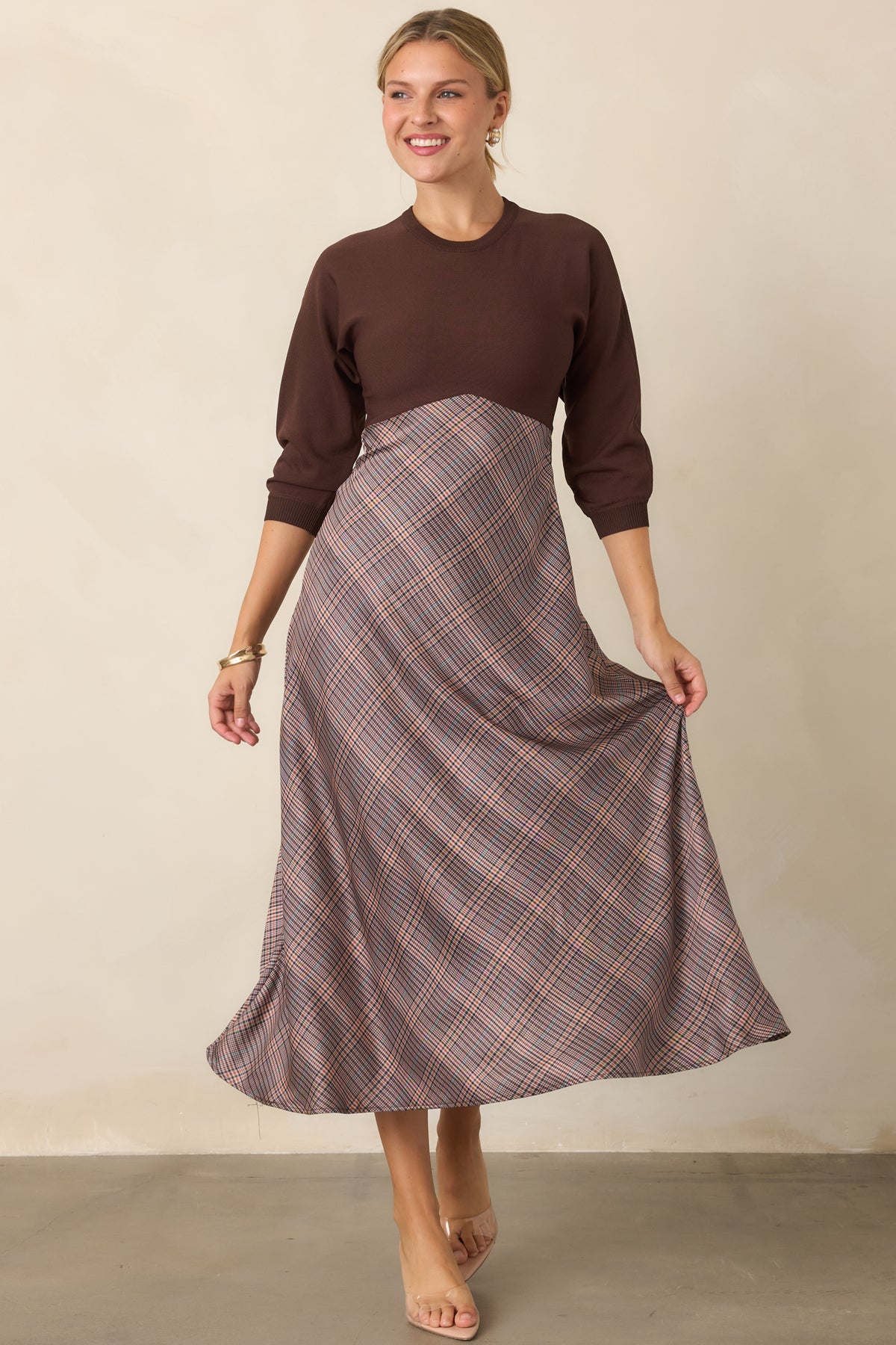 Brown knit dress designed with a fitted silhouette, classic round neckline, and softly structured three-quarter sleeves.