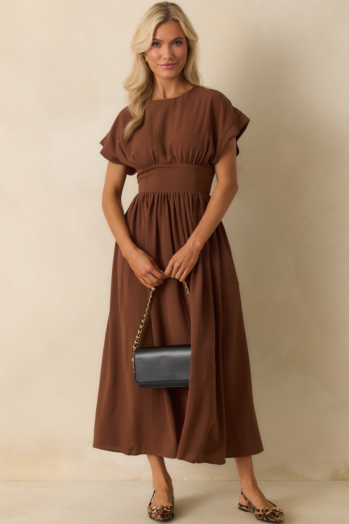 Brown maxi dress with a round neckline, short sleeves, and fitted cinched waistband.