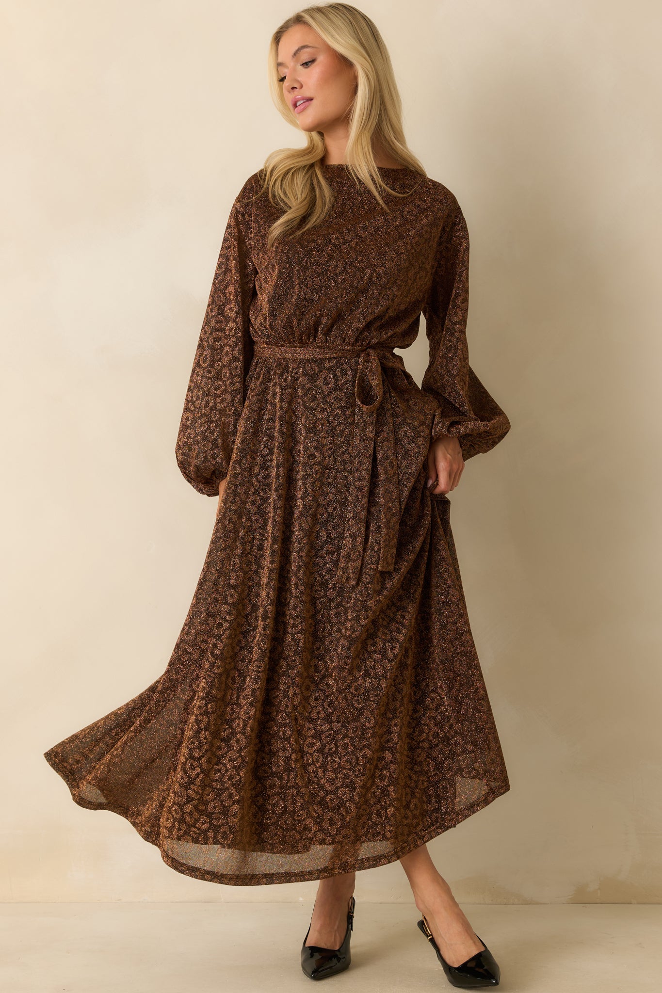 Brown midi dress with a round neckline, long sleeves, and lightweight shimmer fabric cascading to a midi length.