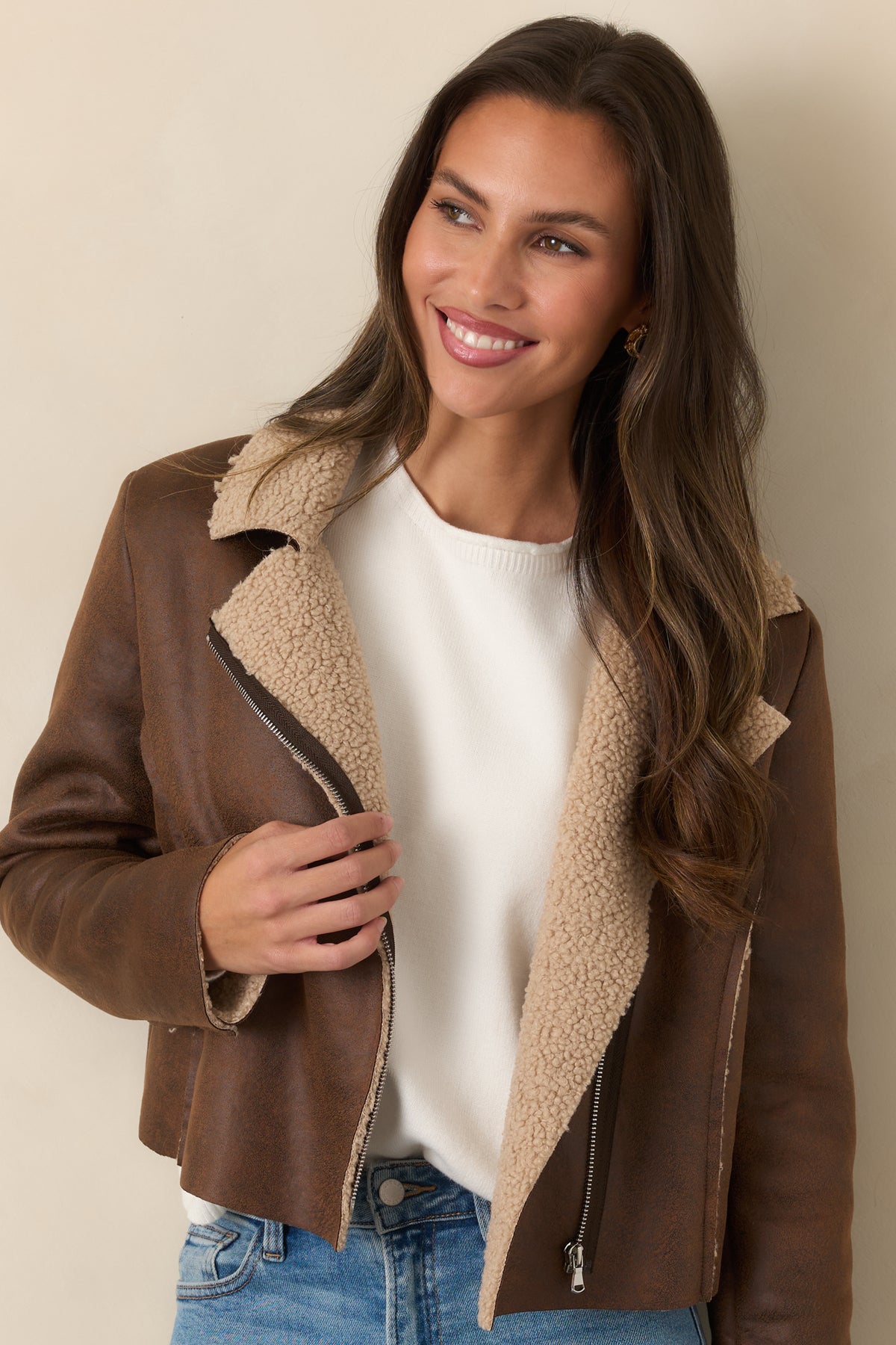 Silver-tone asymmetric zipper across the front of the distressed brown moto jacket.