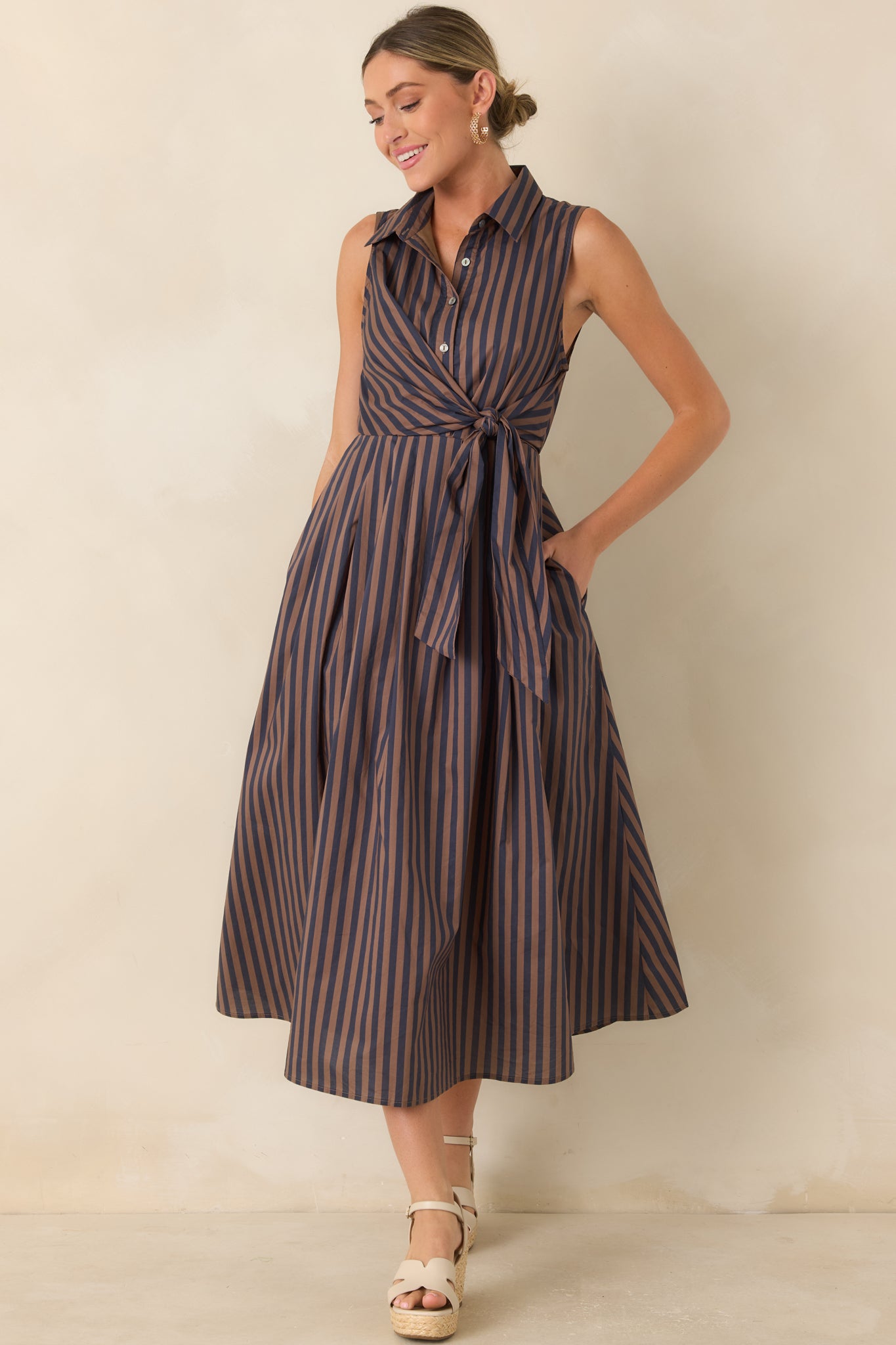 Brown and navy striped cotton midi dress featuring a pointed collar, button-front bodice, front tie waist, and flowing A-line skirt.