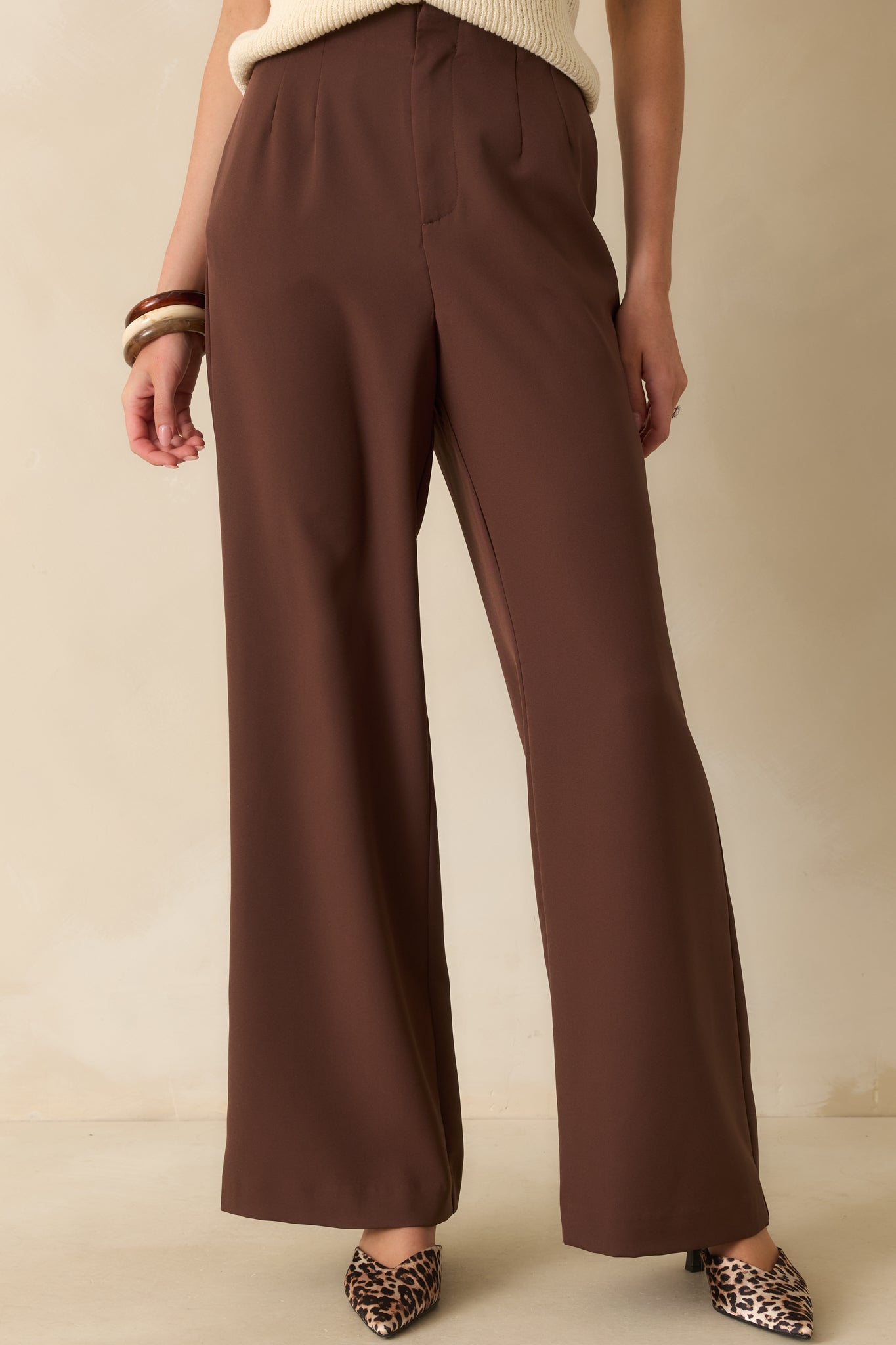 Fabric texture and high-rise waist detail on the front of the brown pants.