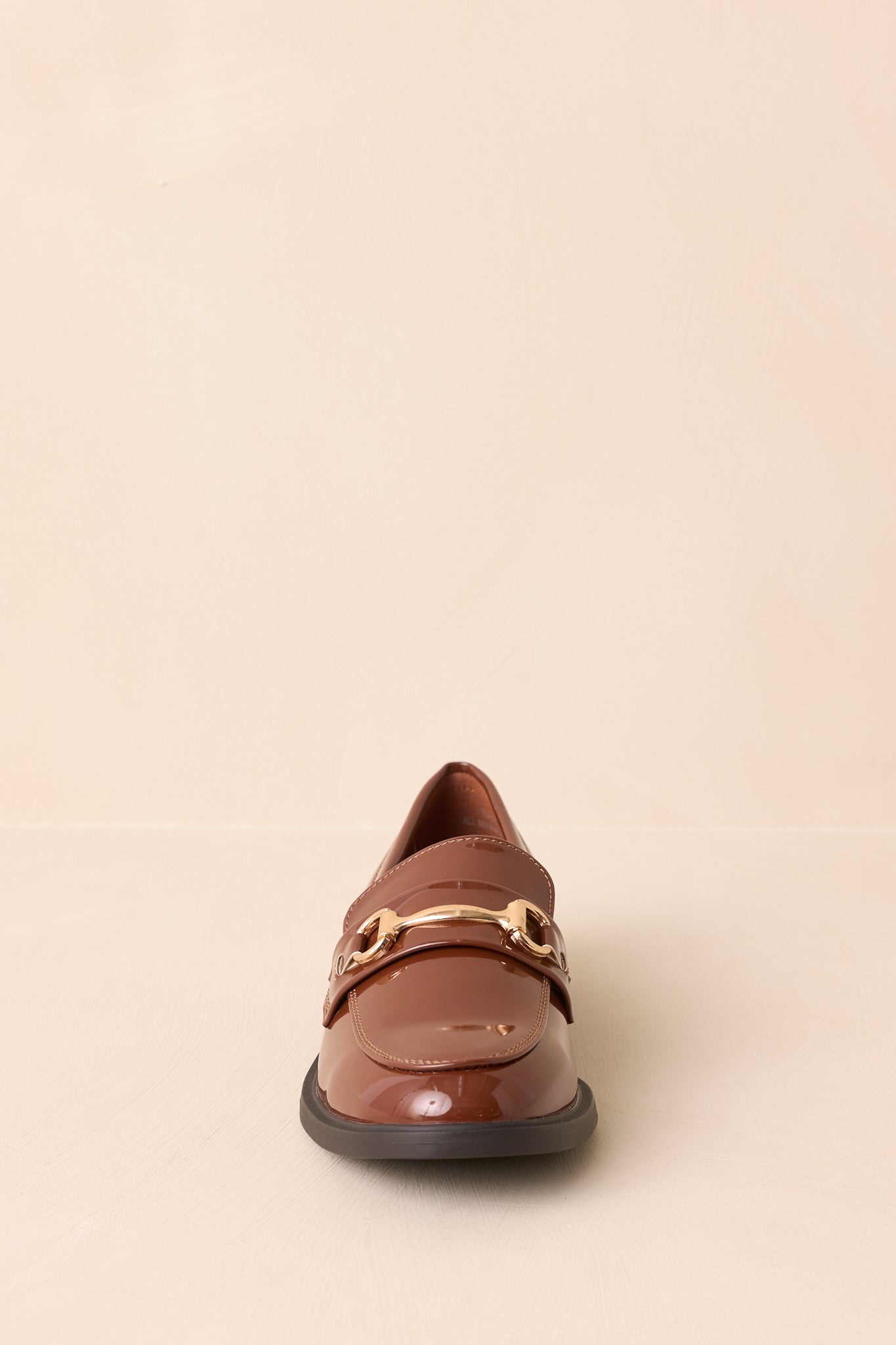 Pair of brown patent loafers with gold-tone horsebit detail and stacked heel.