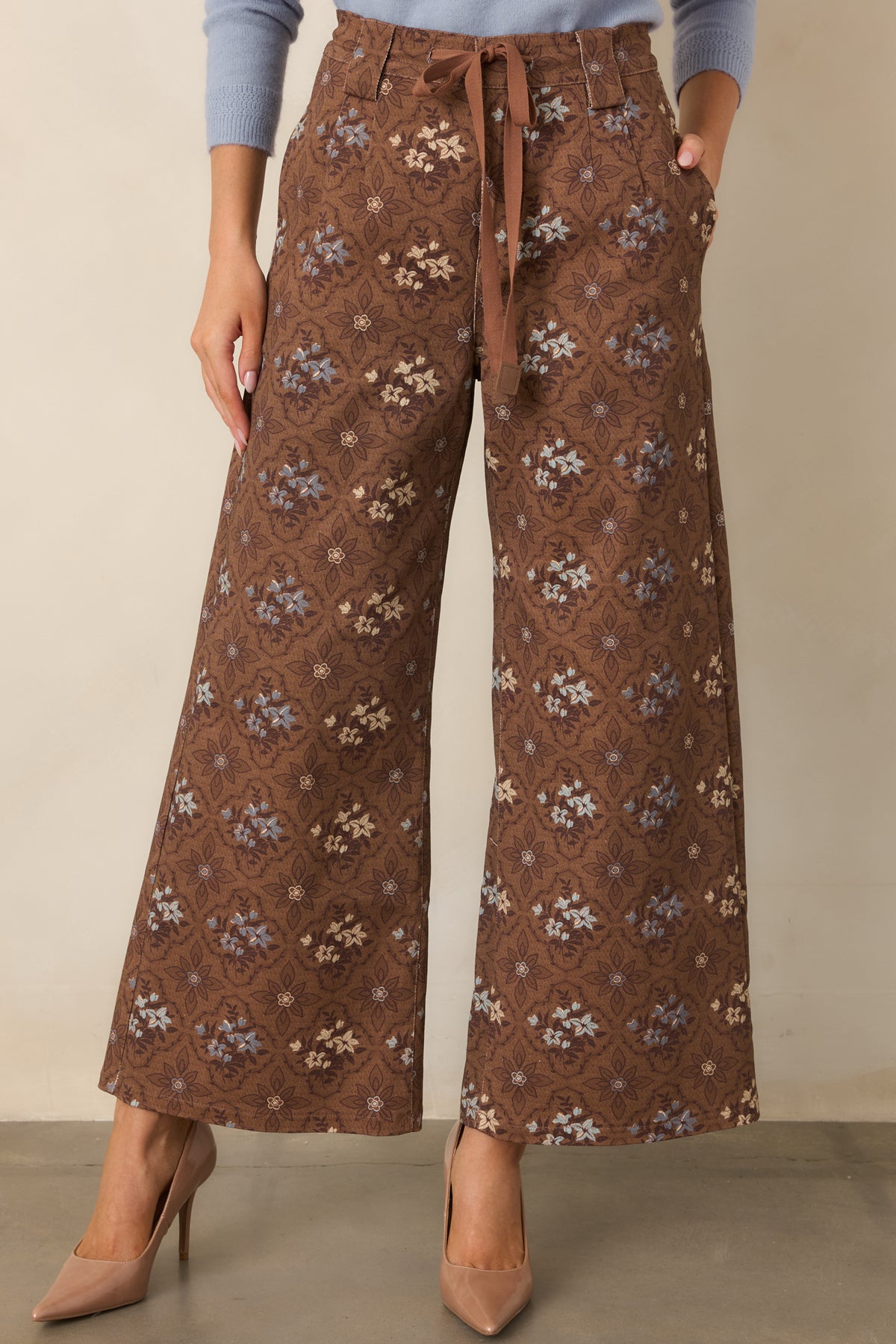 Brown patterned pants featuring functional side pockets and detailed mauve, blue, and cream florals.