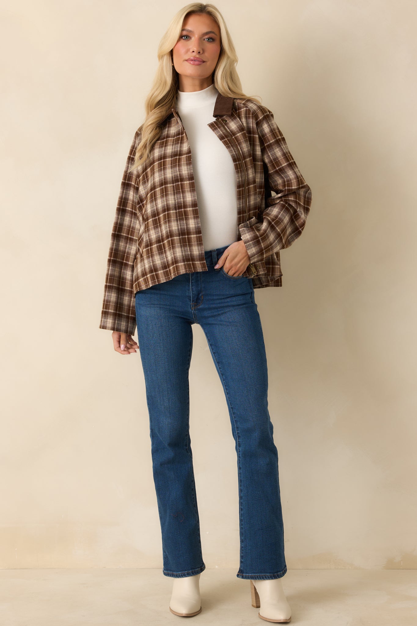Brown plaid jacket showing its boxy silhouette with relaxed long sleeves.