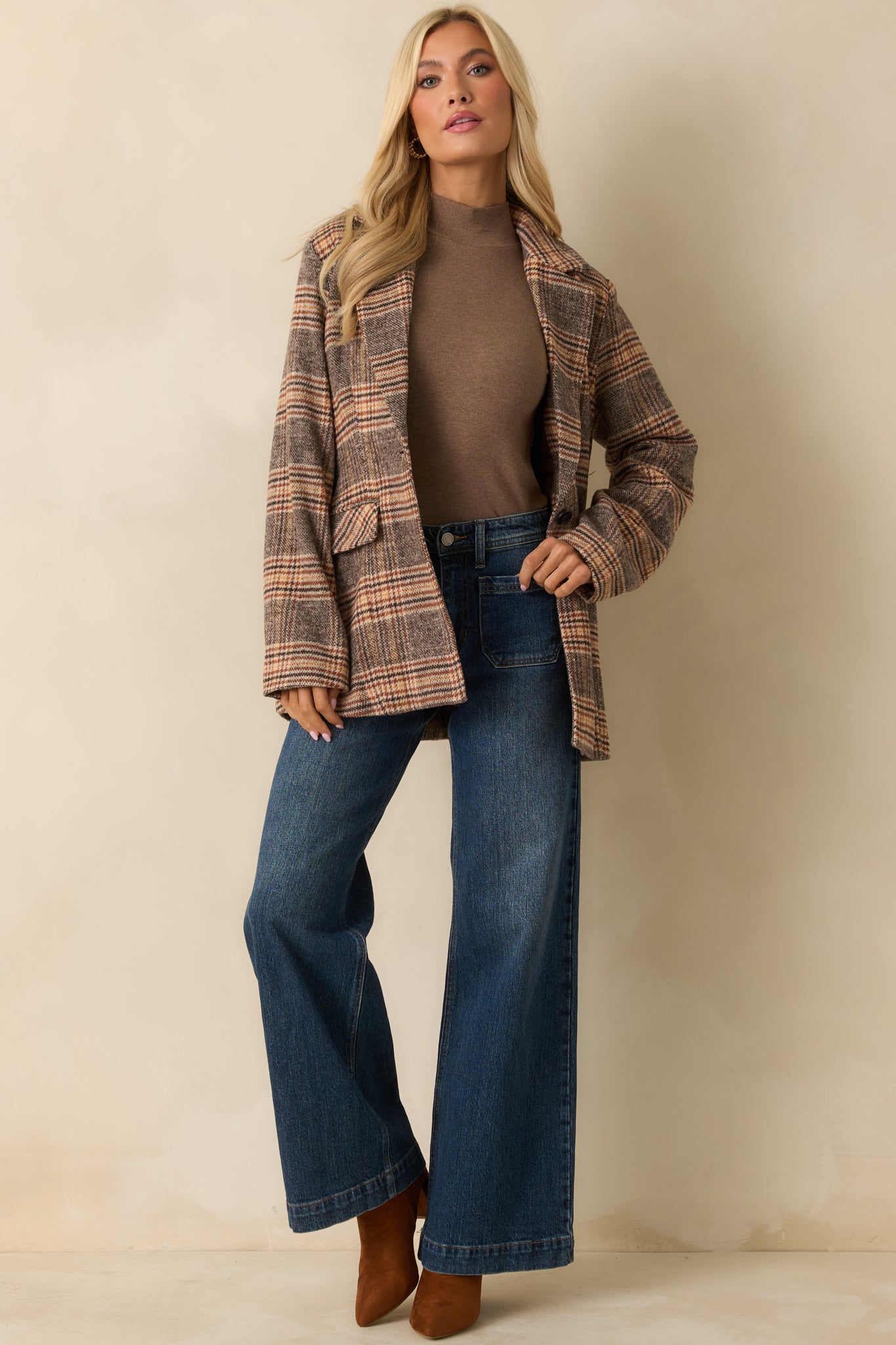 Brown plaid mid-length overcoat with a collared neckline and front buttons, featuring long sleeves and flap pockets.