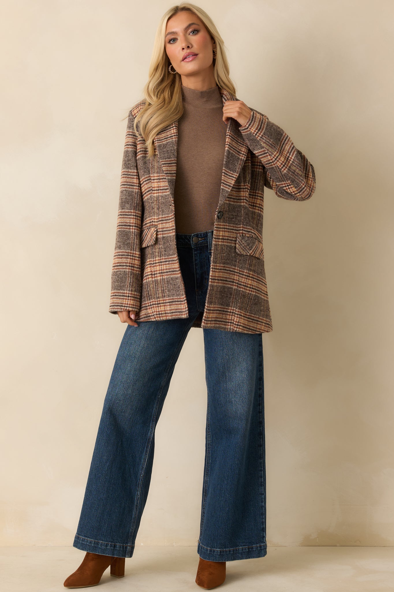 Mid-length brown plaid overcoat with long sleeves, front flap pockets, and button closure displayed straight on.