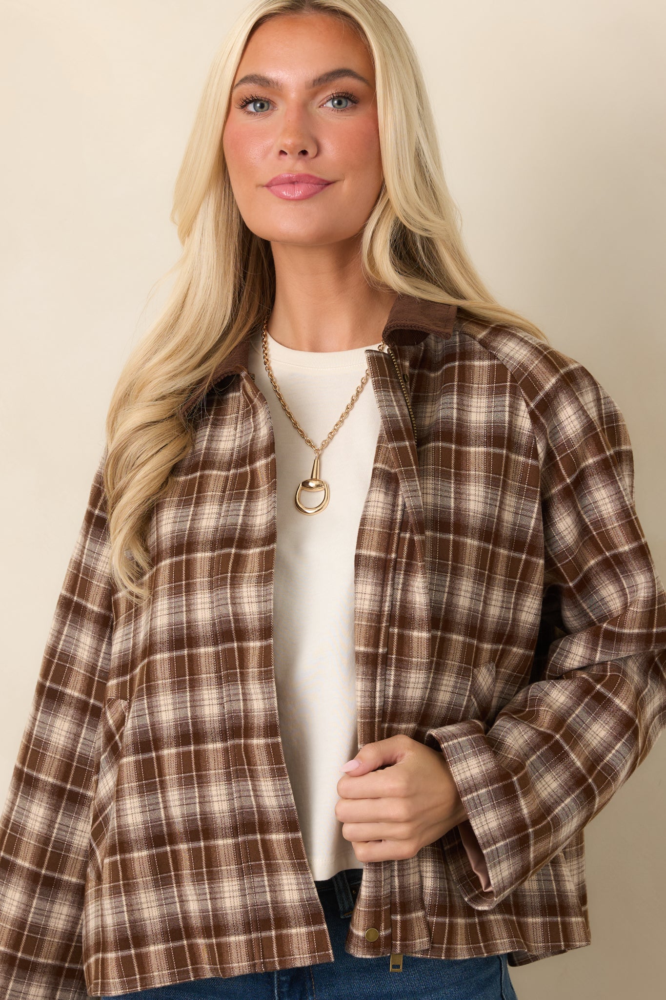 Brown plaid jacket showcasing the functional side pocket and relaxed long-sleeve construction.