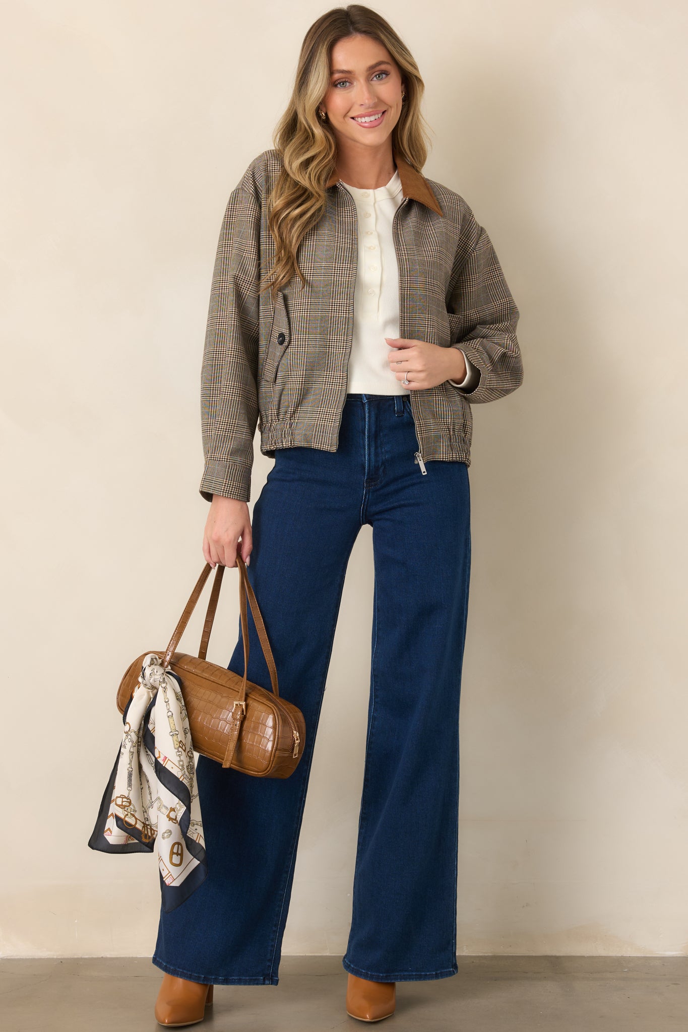 Brown multi-plaid bomber jacket featuring a contrasting corduroy collar, full zip closure, buttoned flap pockets, and an elasticized hem.