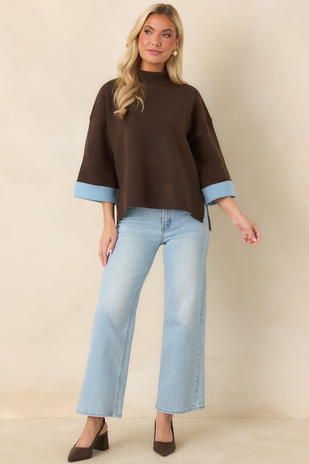 Relaxed brown sweater featuring a boxy silhouette, wide three-quarter sleeves, and contrasting blue cuffs.