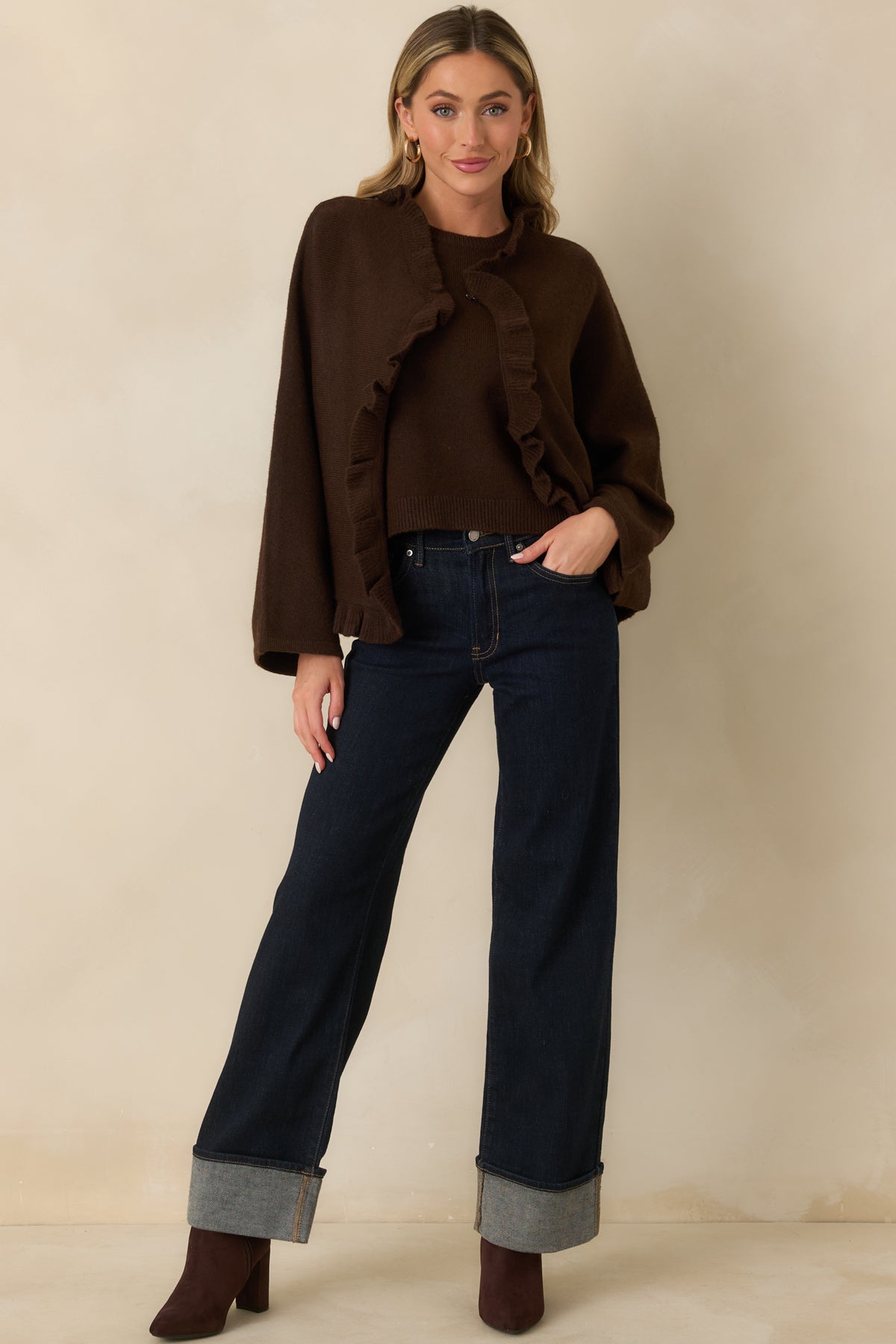 Relaxed brown cardigan with a flowing cape-like shape, wide sleeves, and delicate ruffle trim along the edges.