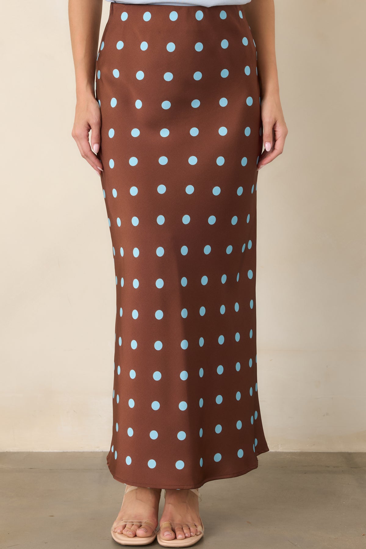 Detailed view of the silky skirt revealing its fluid satin texture and evenly spaced light blue polka dots.