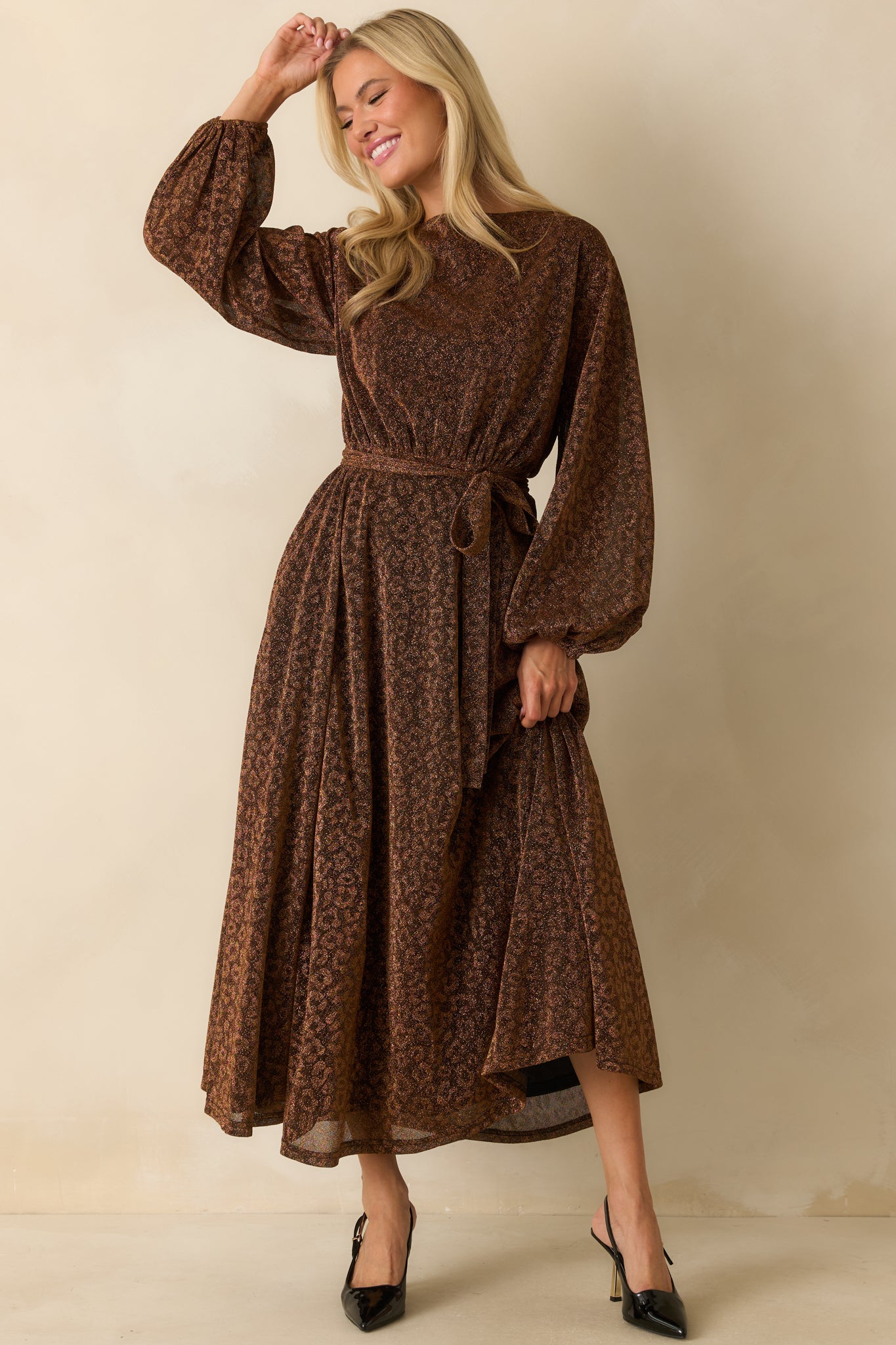 Brown shimmer midi dress with long sleeves and a softly gathered elastic waist, highlighting the flowing skirt and lightweight, subtly sparkling fabric.