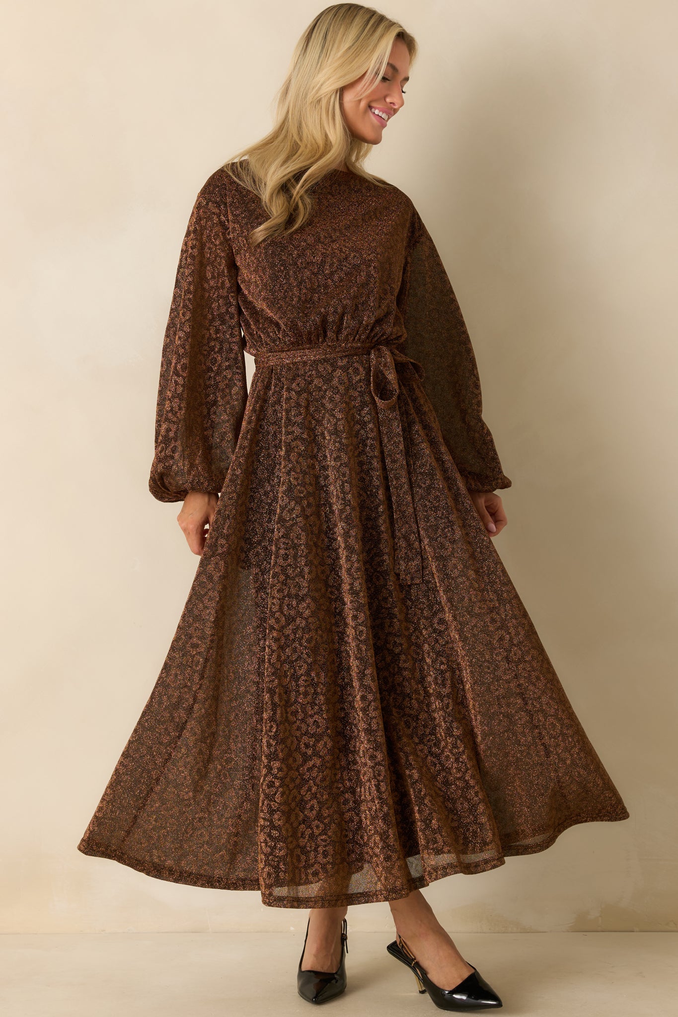 Brown shimmer midi dress with long sleeves and a round neckline, featuring a flowy skirt with subtle shine.