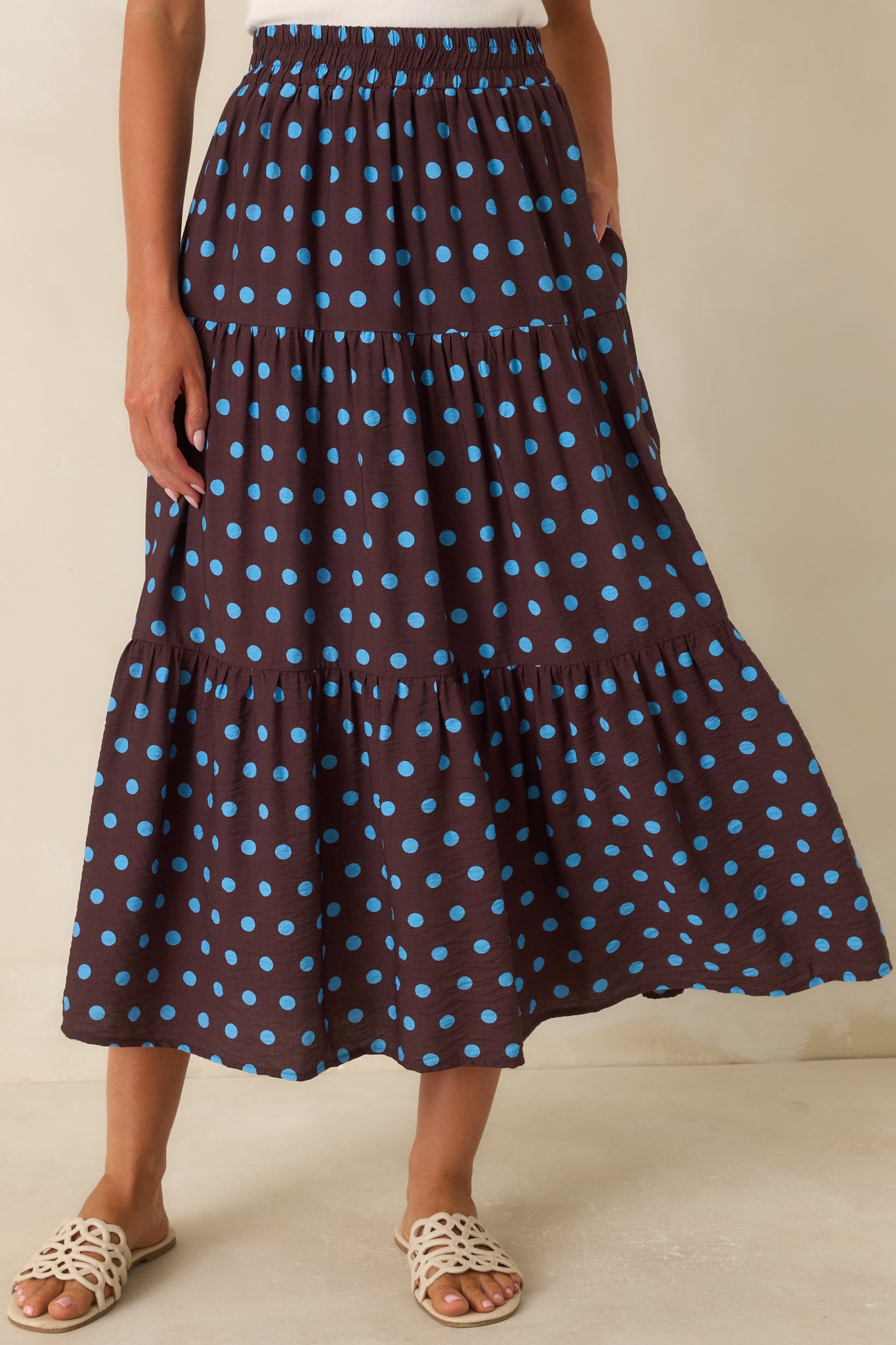 Detailed view highlighting the vibrant blue polka dot pattern and lightweight fabric texture of the skirt.