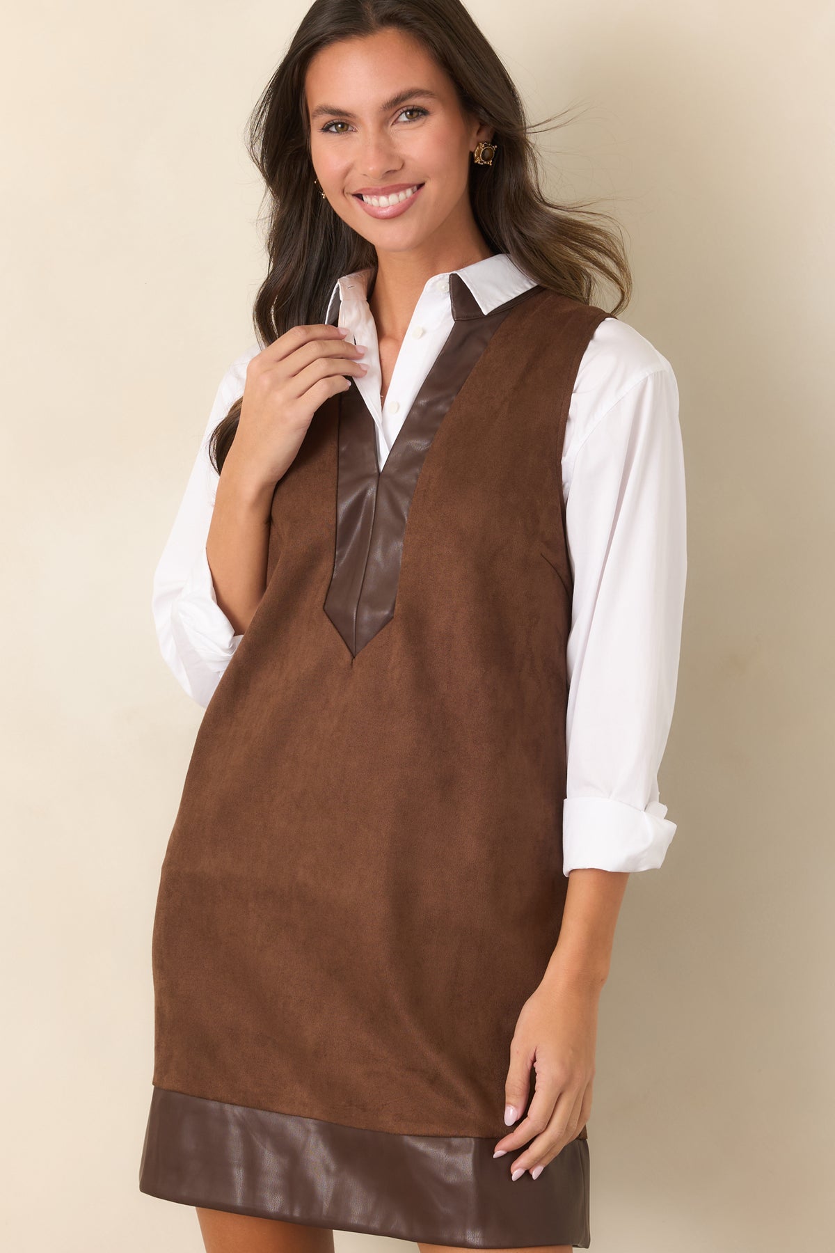 Sleeveless mini dress featuring an elongated neckline detail that extends down the front.
