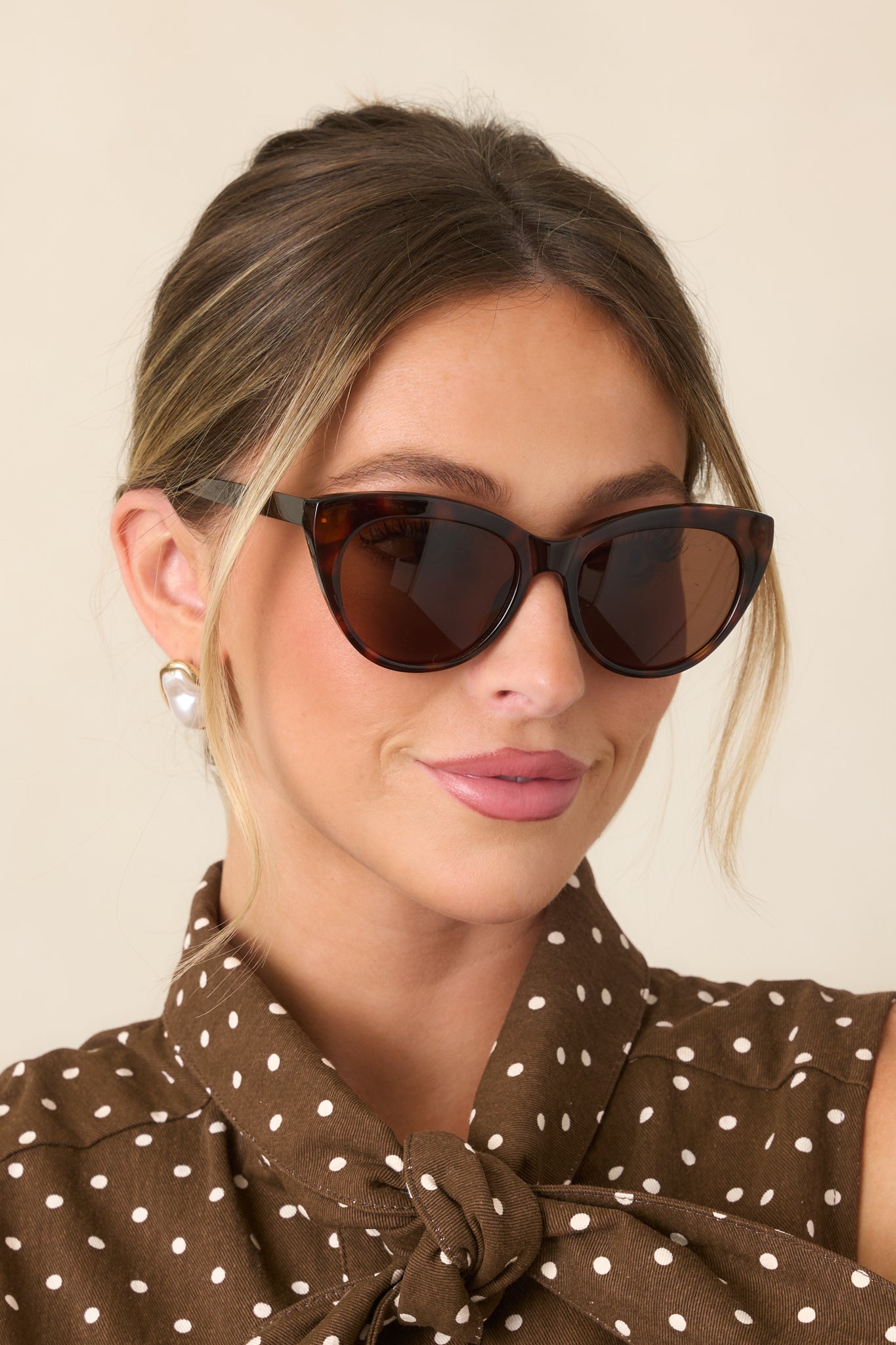 Rich brown tortoise sunglasses featuring a softly sculpted cat-eye frame, subtly lifted outer corners, and tinted lenses.