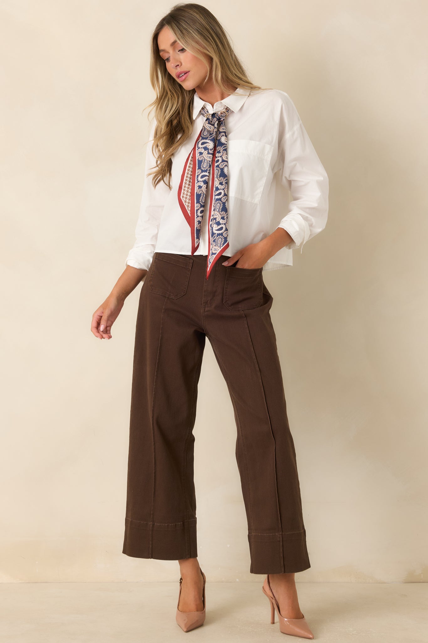 Rich brown utility-inspired pants with a structured high-rise fit, belt loops, front patch pockets, and tailored wide-leg silhouette.
