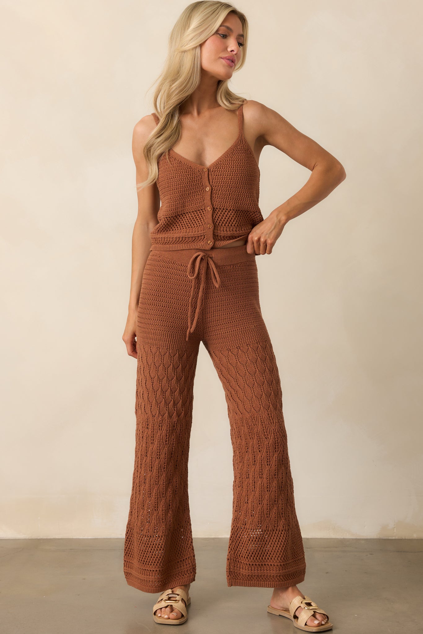 Brown wide-leg pants with a split crochet pattern and elastic waistband, styled with a relaxed fit.