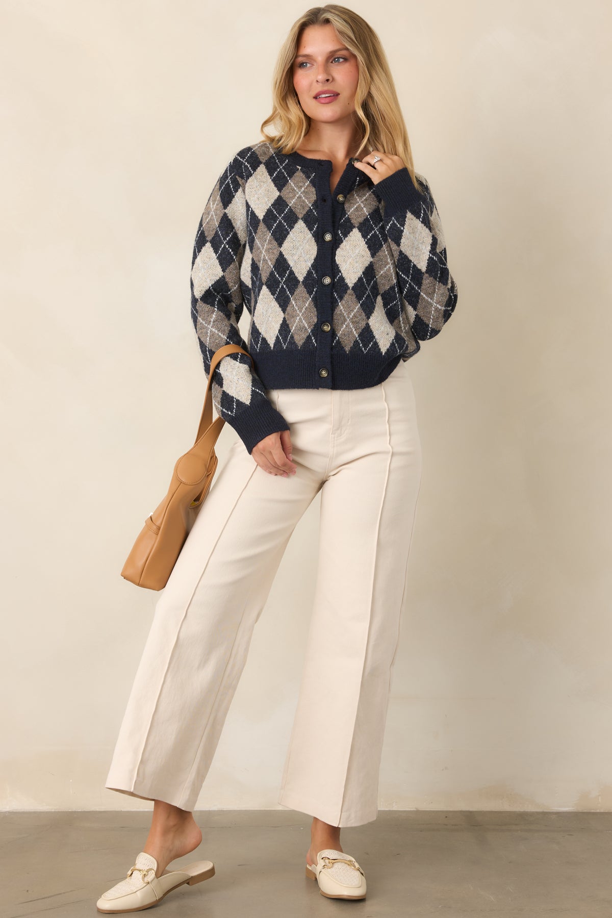 Brushed knit cardigan with a classic button-front silhouette, ribbed crew neckline, navy trim, and long sleeves.