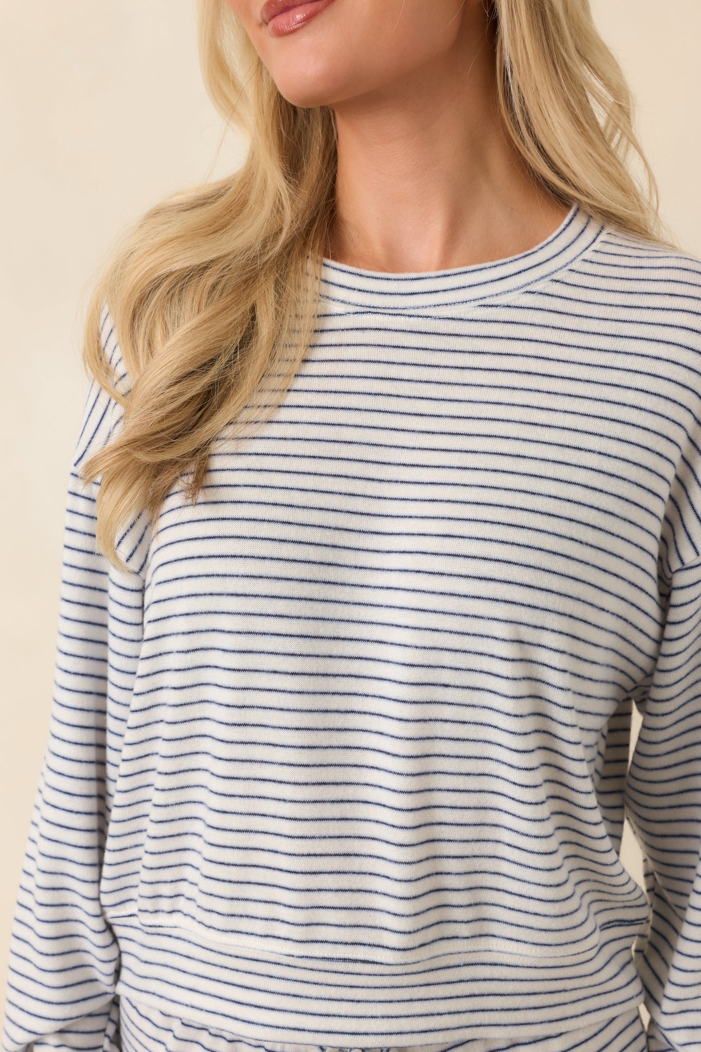 Close-up detail of the brushed sweater knit fabric and navy stripe design on the pullover.