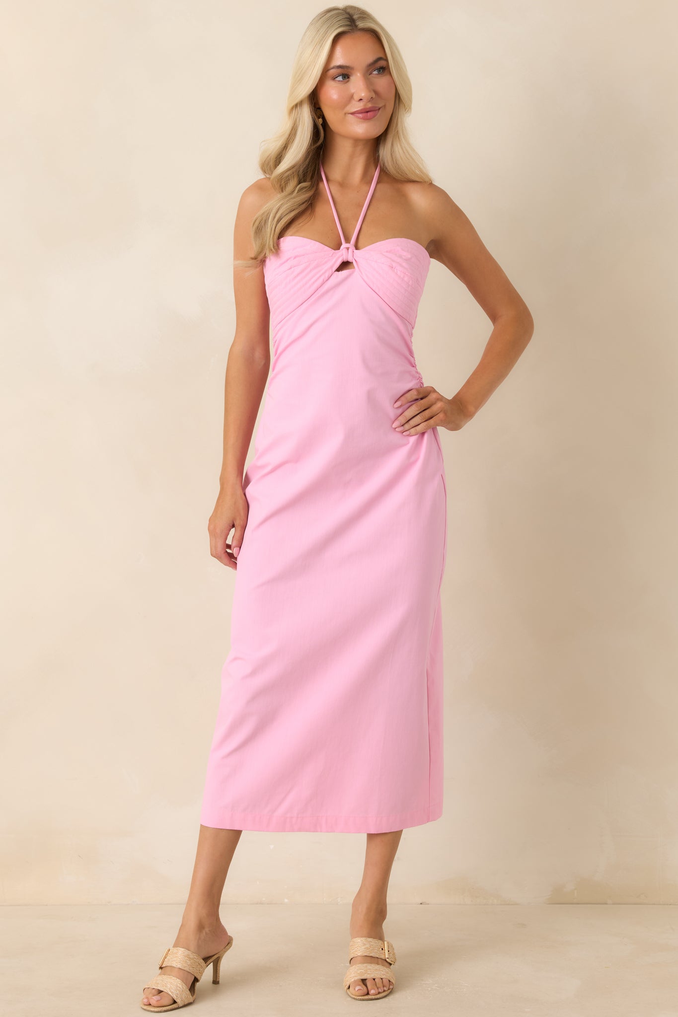 Bubblegum pink dress with a fitted bodice, ruched waist, and flowing midi skirt.