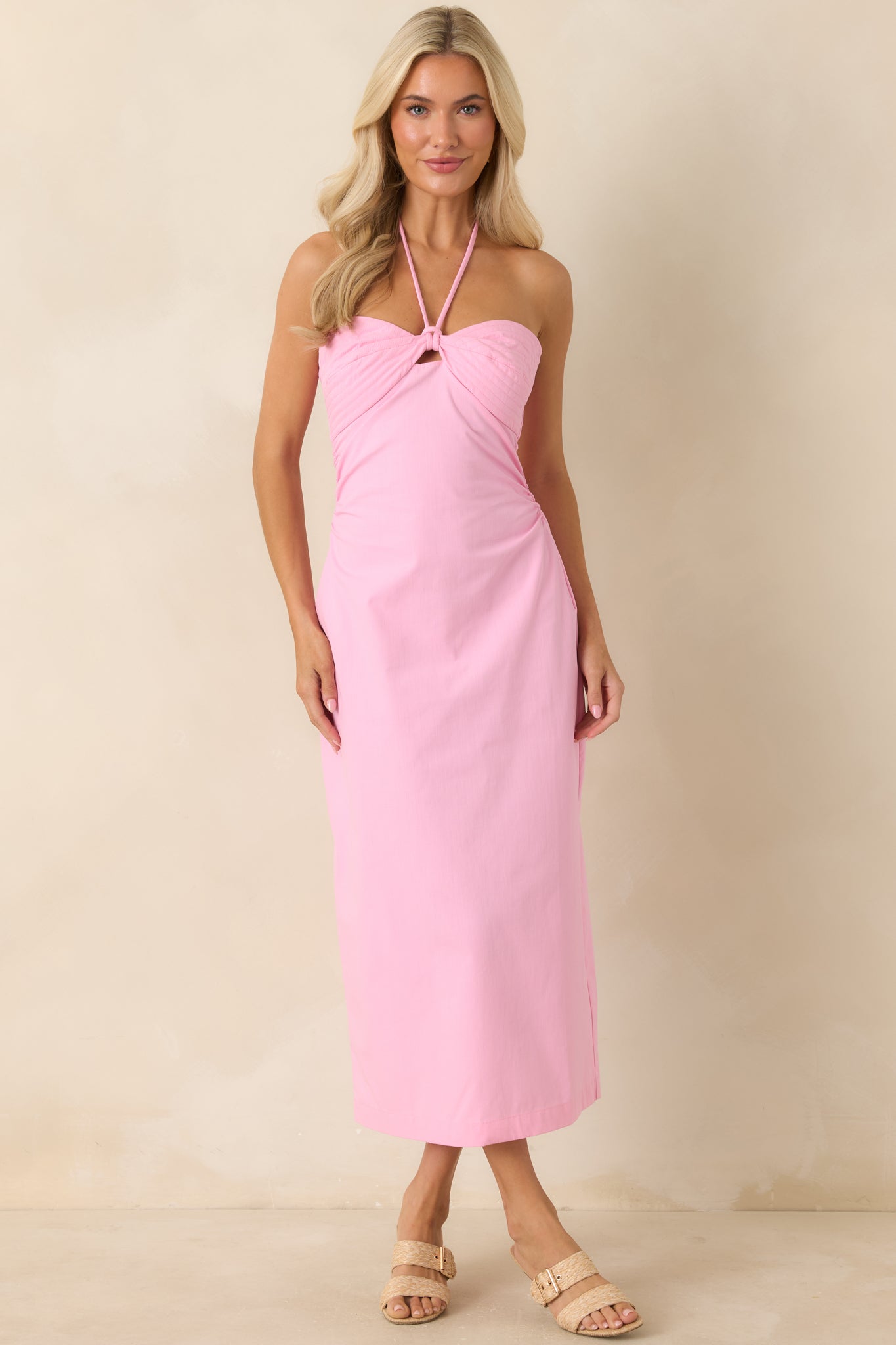 Bubblegum pink midi dress featuring a halter neckline, ruched waist, and fitted bodice silhouette.
