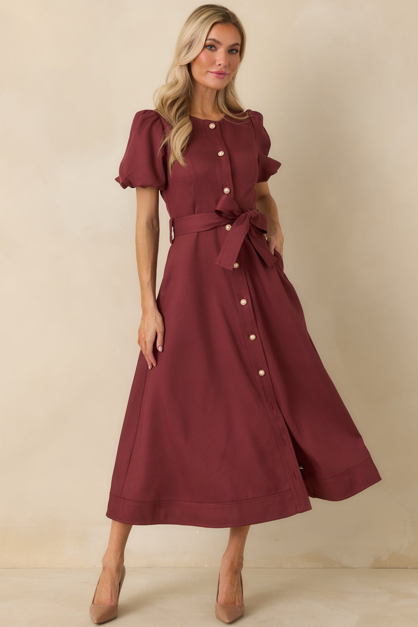 Burgundy A-line midi dress with a fitted bodice, short puff sleeves, pearl button front, and removable waist tie.
