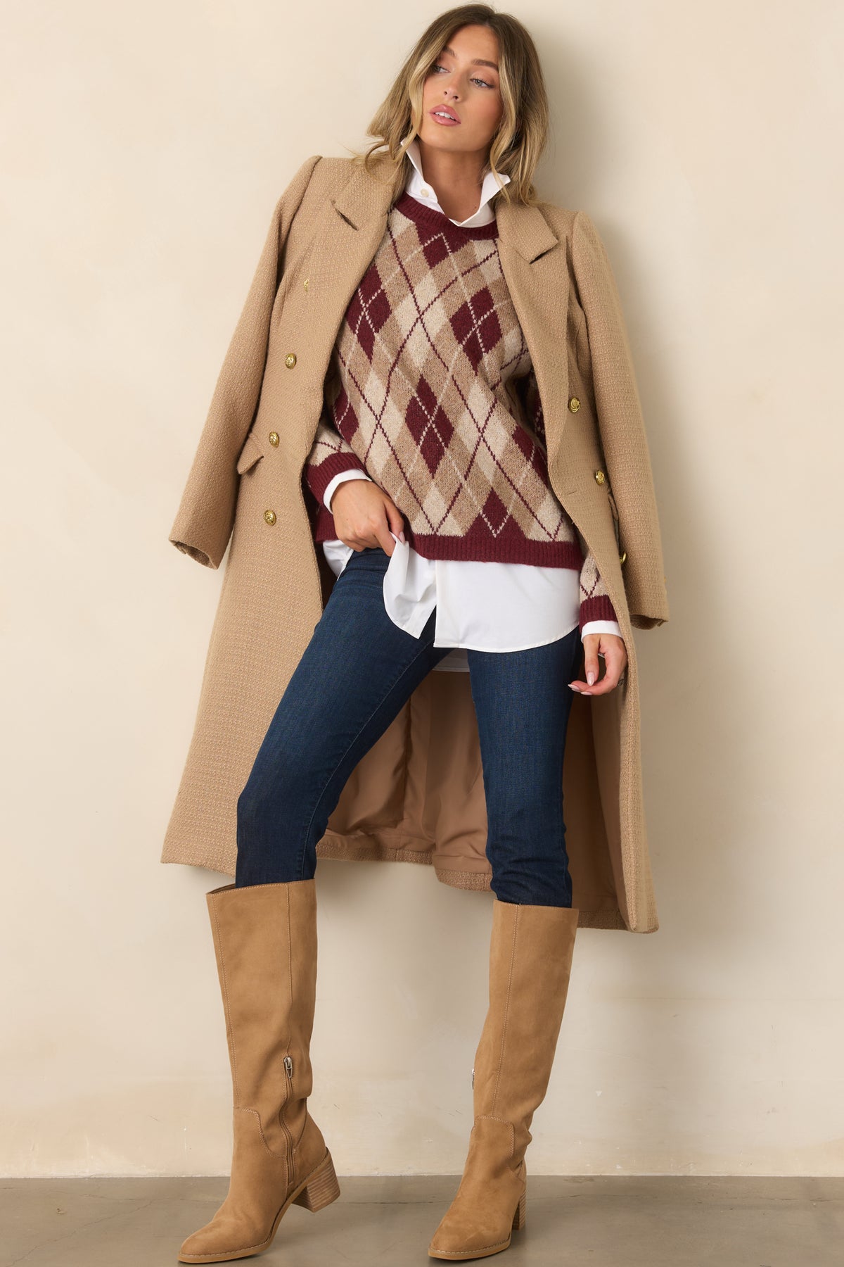 A classic crew neckline and long sleeves frame the burgundy argyle knit design with coordinating neutral tones.