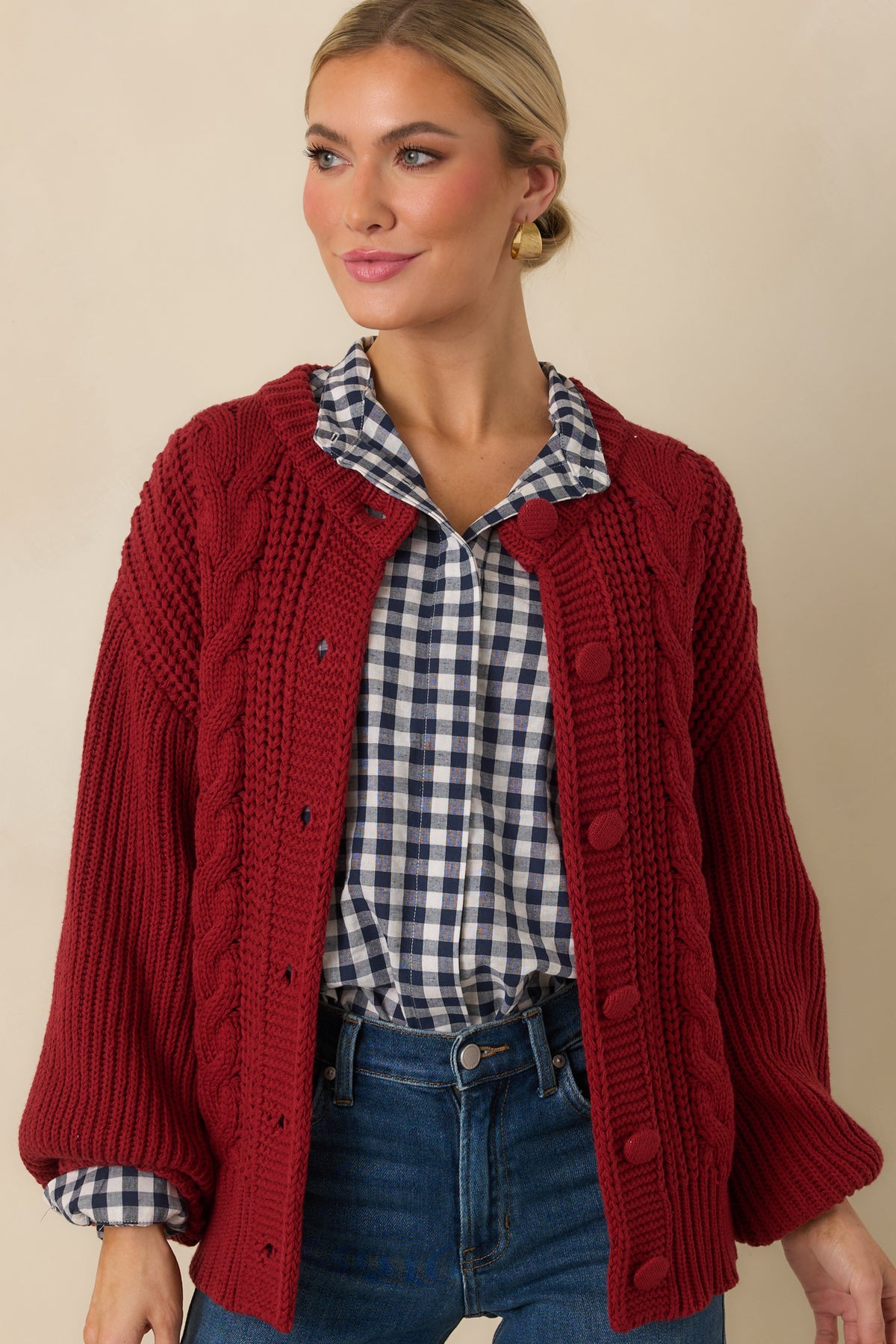 Burgundy cardigan highlighting the transition from chunky front cable knitting to the ribbed shoulder and sleeve texture.