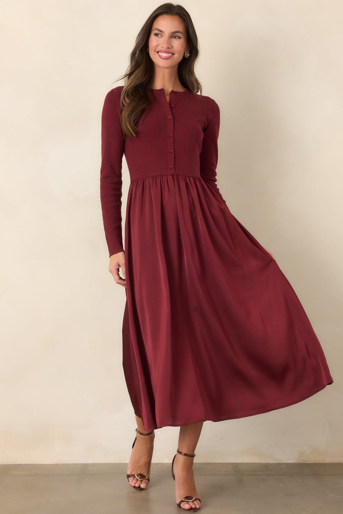 Cardigan-inspired burgundy dress with tonal buttons and a lustrous gathered skirt flowing from the defined waist.