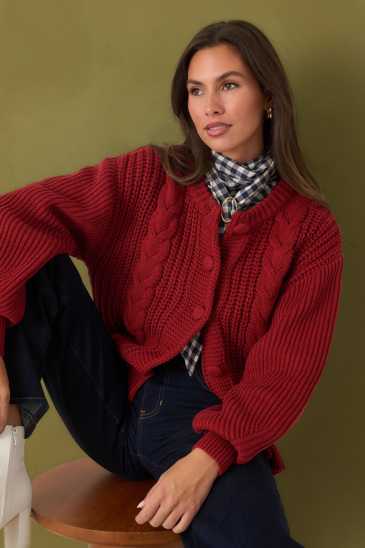 Burgundy cardigan showing the chunky cable-knit detailing running vertically down the front.