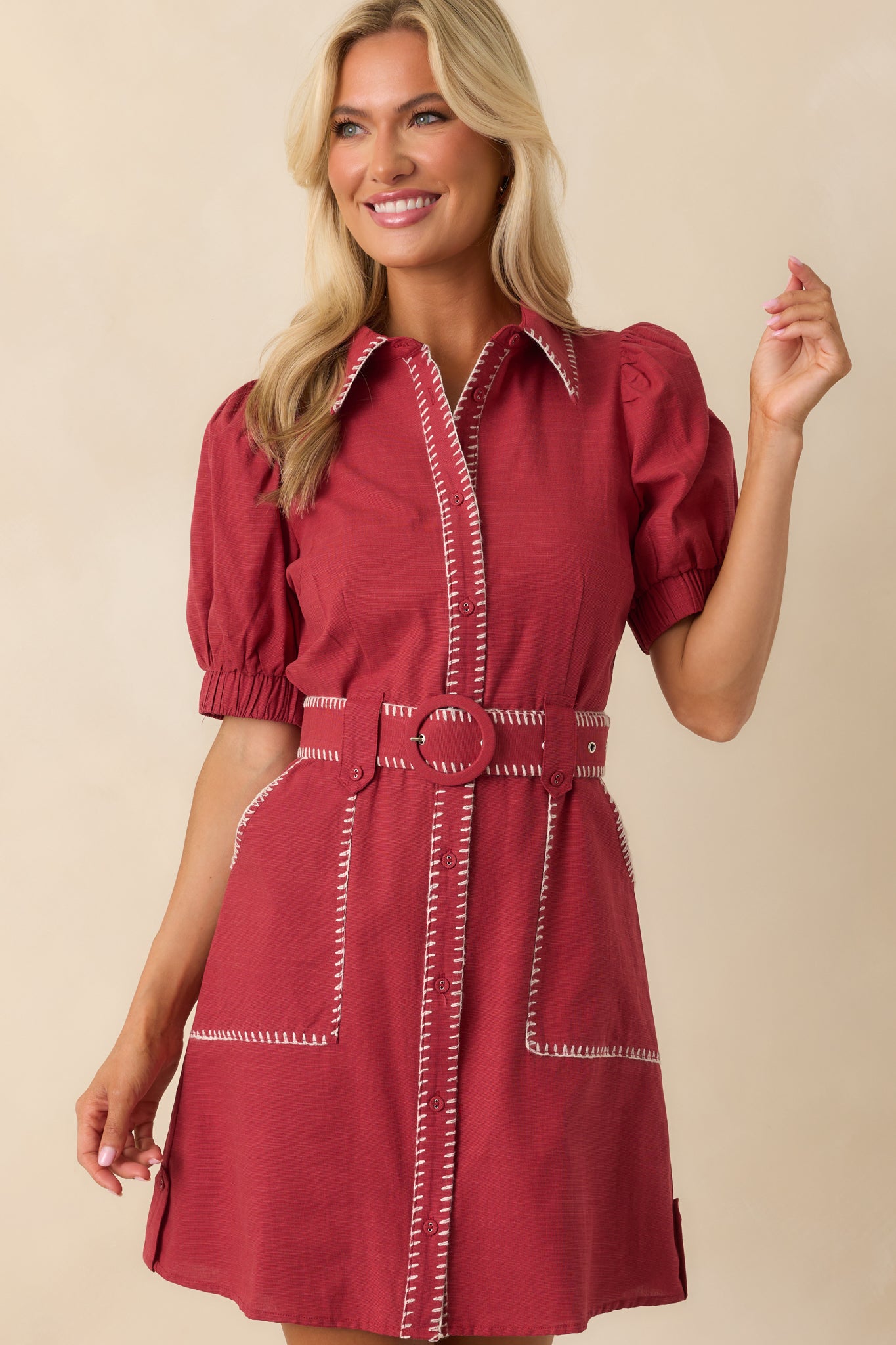 Front view of the burgundy mini dress featuring a collared neckline, short puff sleeves, and white contrast blanket stitching along the edges.