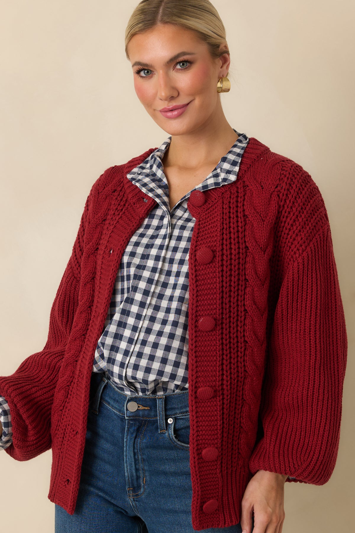 Chunky cable-knit pattern creates a textured front on the burgundy cotton-blend cardigan.
