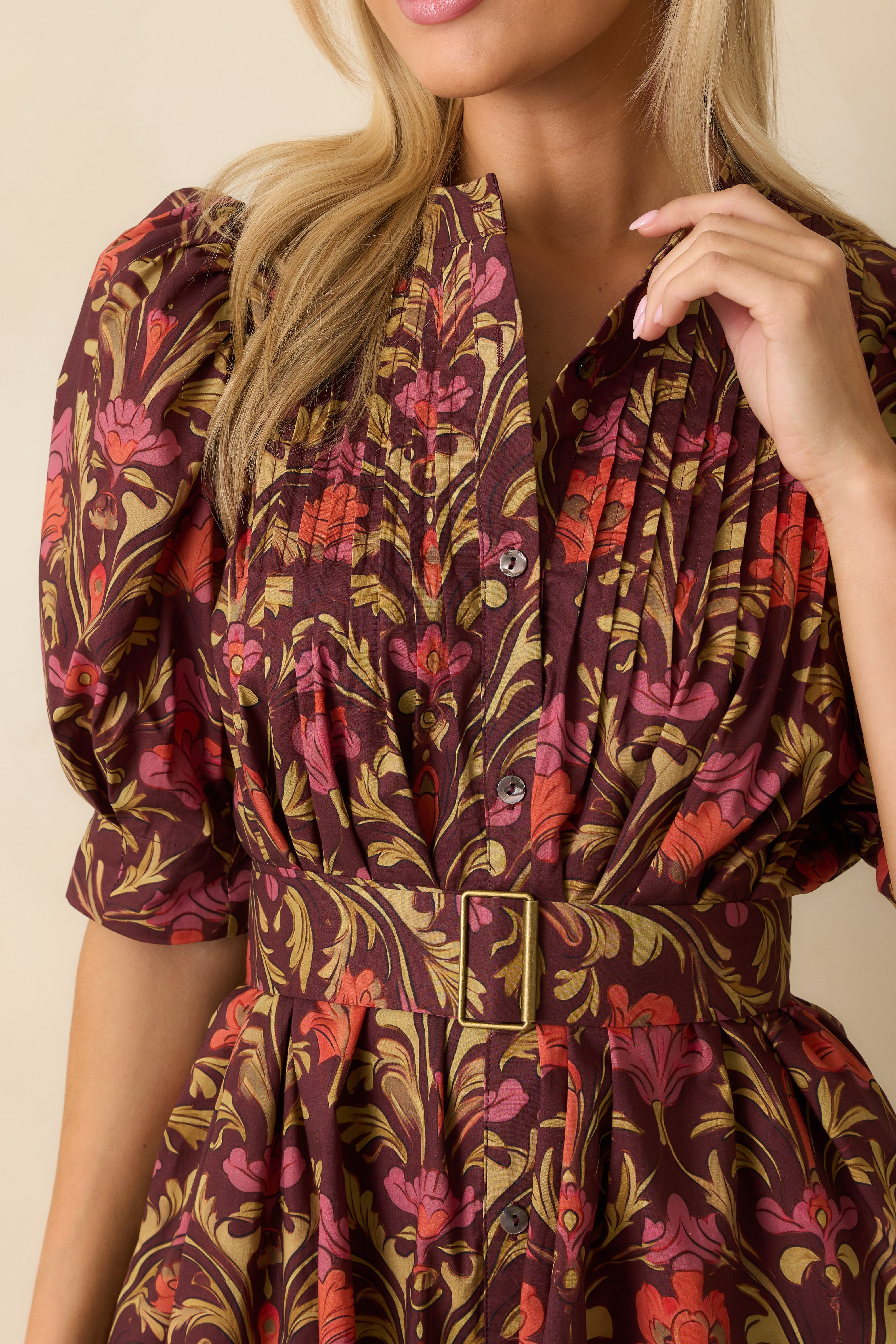 Close-up of the burgundy floral fabric showing the button detailing and textured pleats.