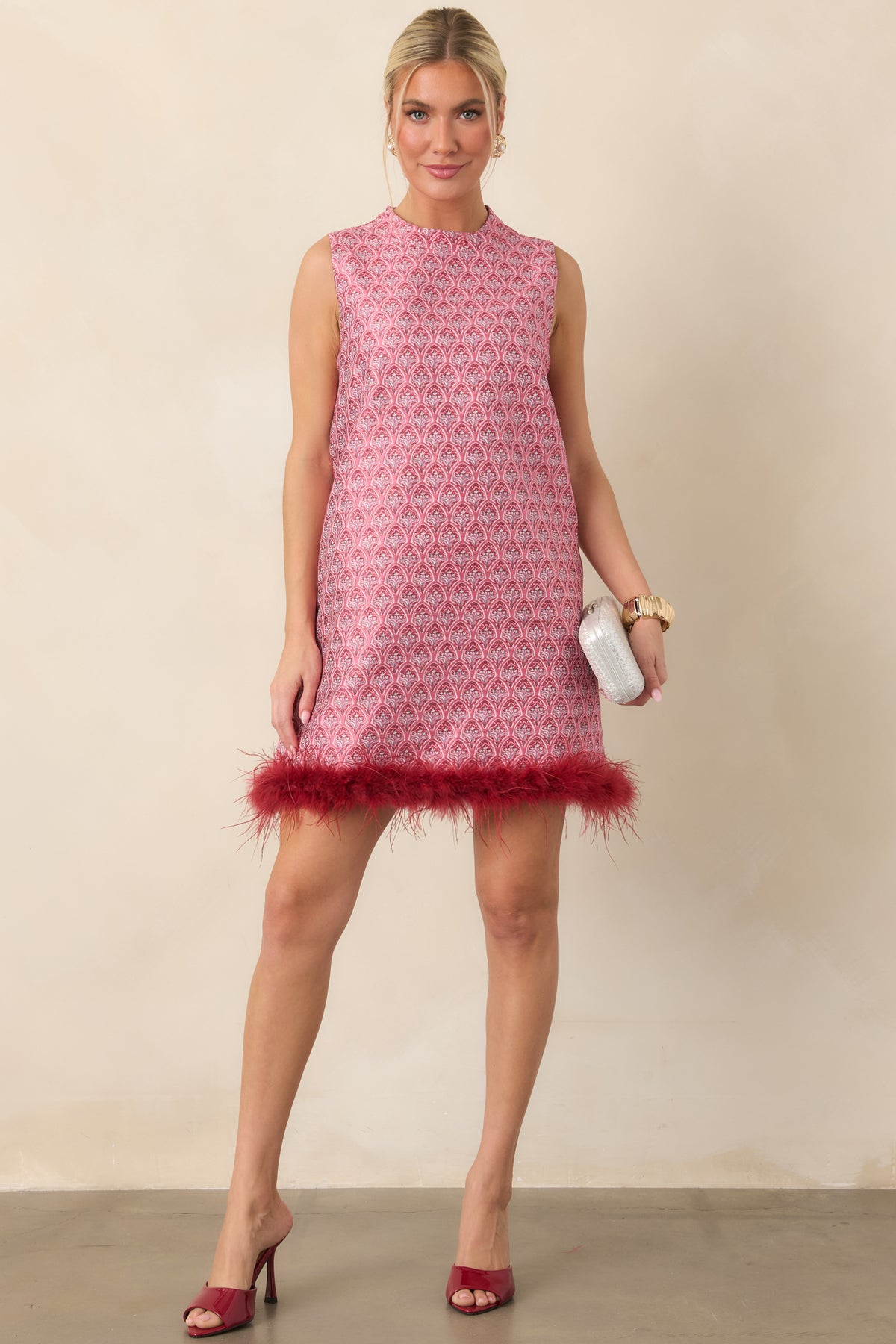 Sleeveless floral mini dress with a high round neckline and burgundy feather trim along the hem.