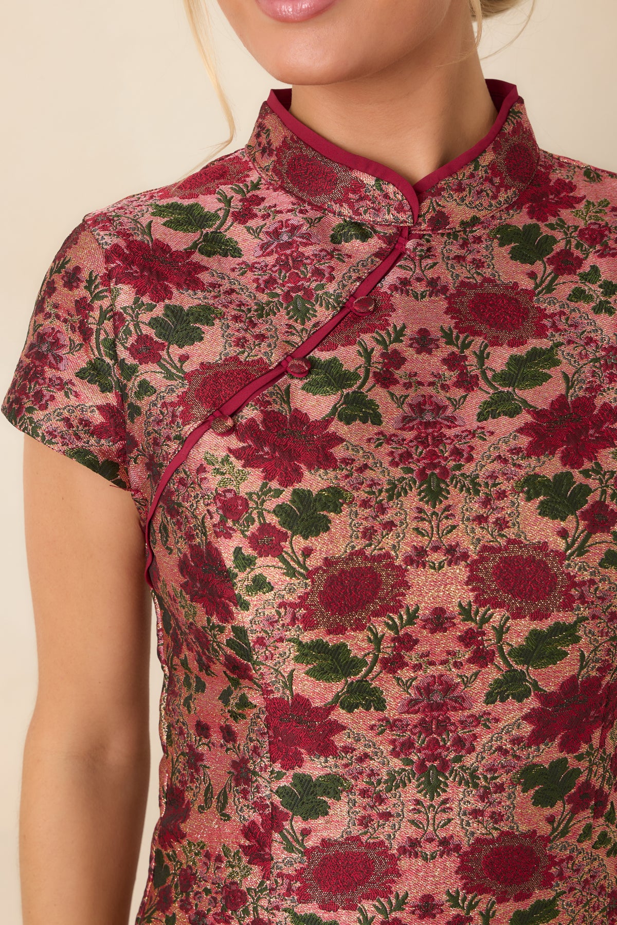 Textured jacquard fabric showcases burgundy floral motifs, deep green foliage, and coordinating burgundy trim.