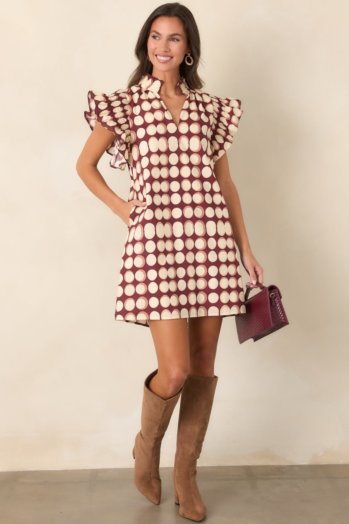 Burgundy cotton shift mini dress with softly shaded ivory dots, ruffled neckline detailing, flutter sleeves, and a loose silhouette.