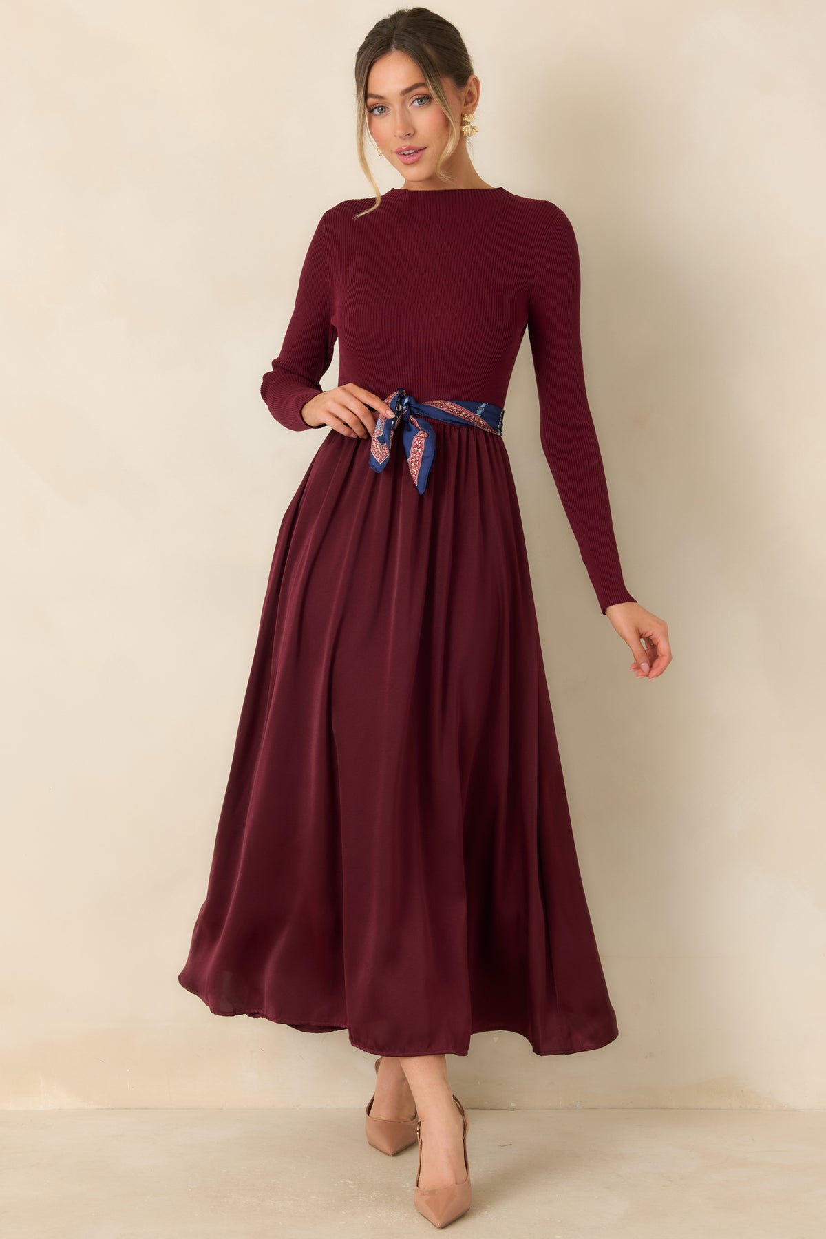 Rich burgundy dress combining a softly structured knit bodice with a flowing satin skirt and lined finish.