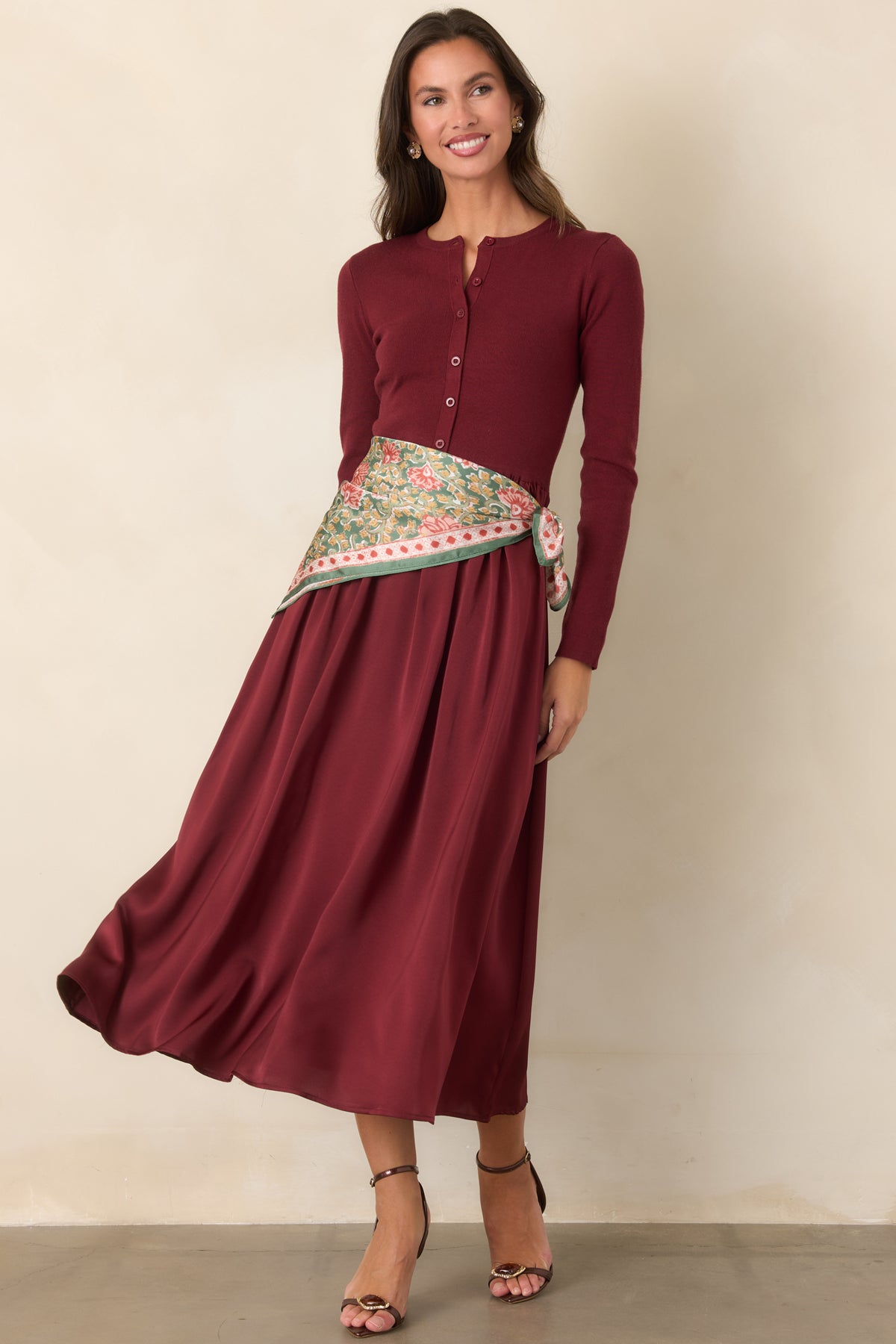 Burgundy midi dress with a cardigan-style knit bodice, round neckline, tonal buttons, and gathered satin skirt.