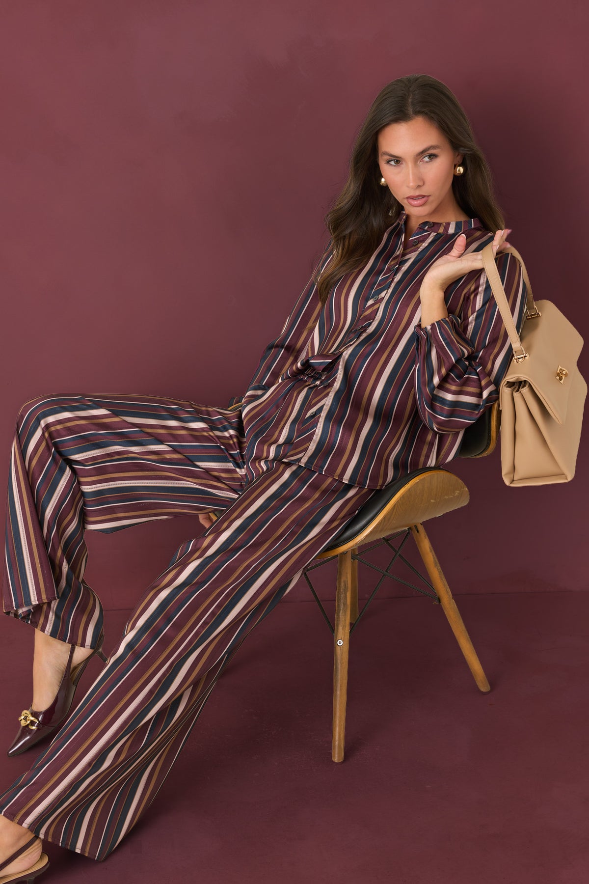 Flowing satin pants featuring vertical burgundy, navy, champagne, and olive stripes.