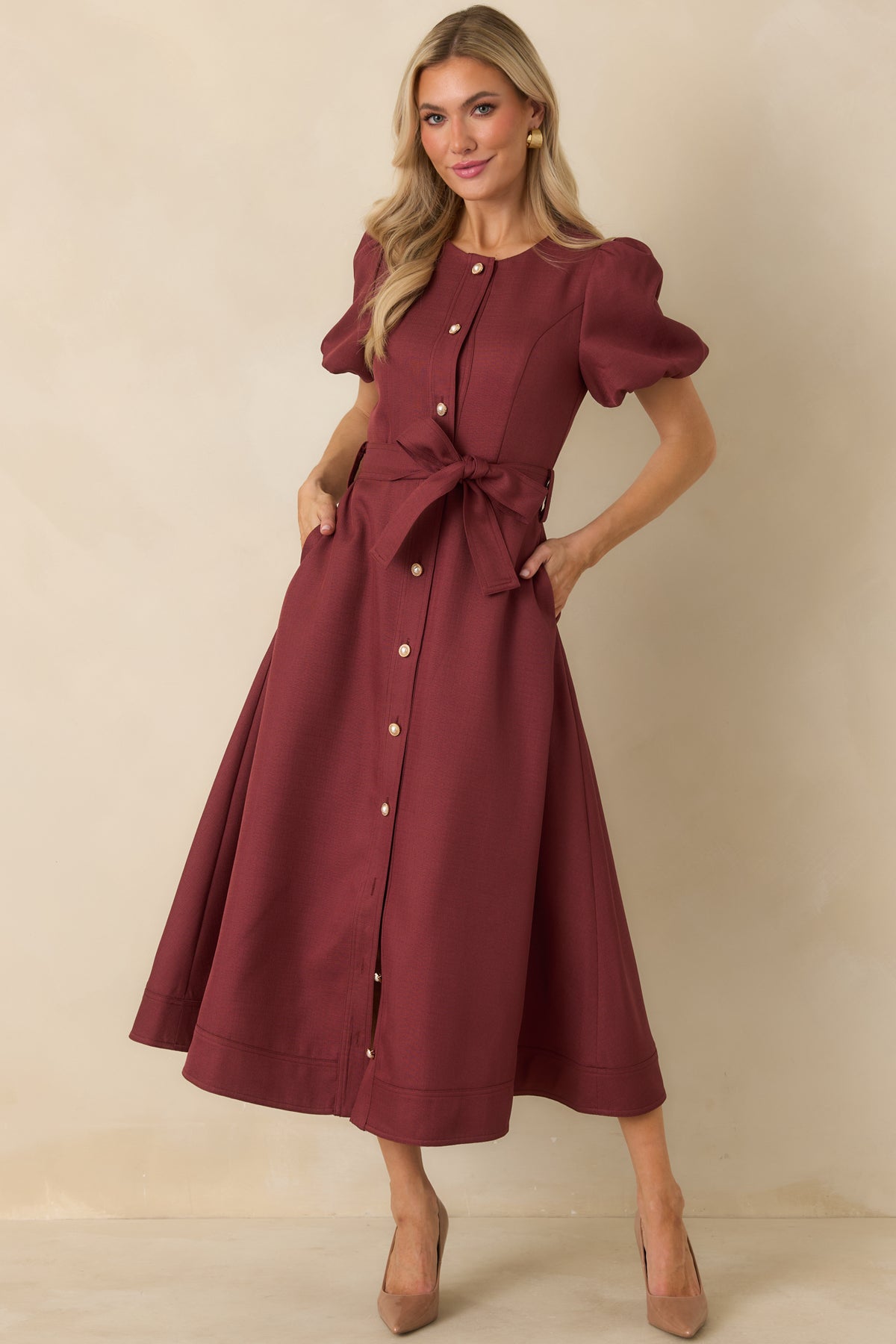 Burgundy midi dress with short puff sleeves, pearl and gold buttons, a self-tie waist belt, and structured A-line skirt.