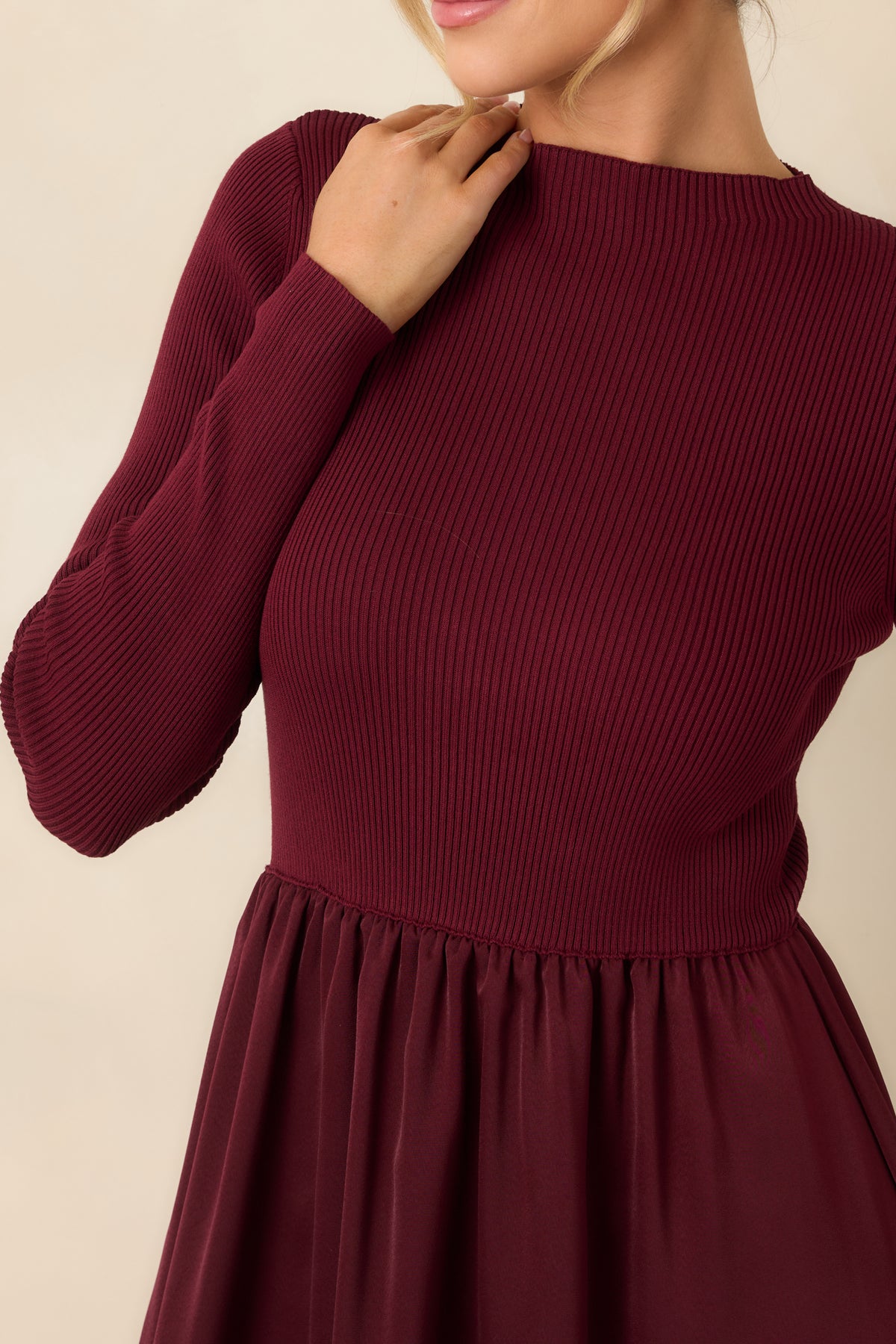 Close-up of the burgundy dress’s ribbed knit texture, subtle mock neckline, and long sleeve detailing.