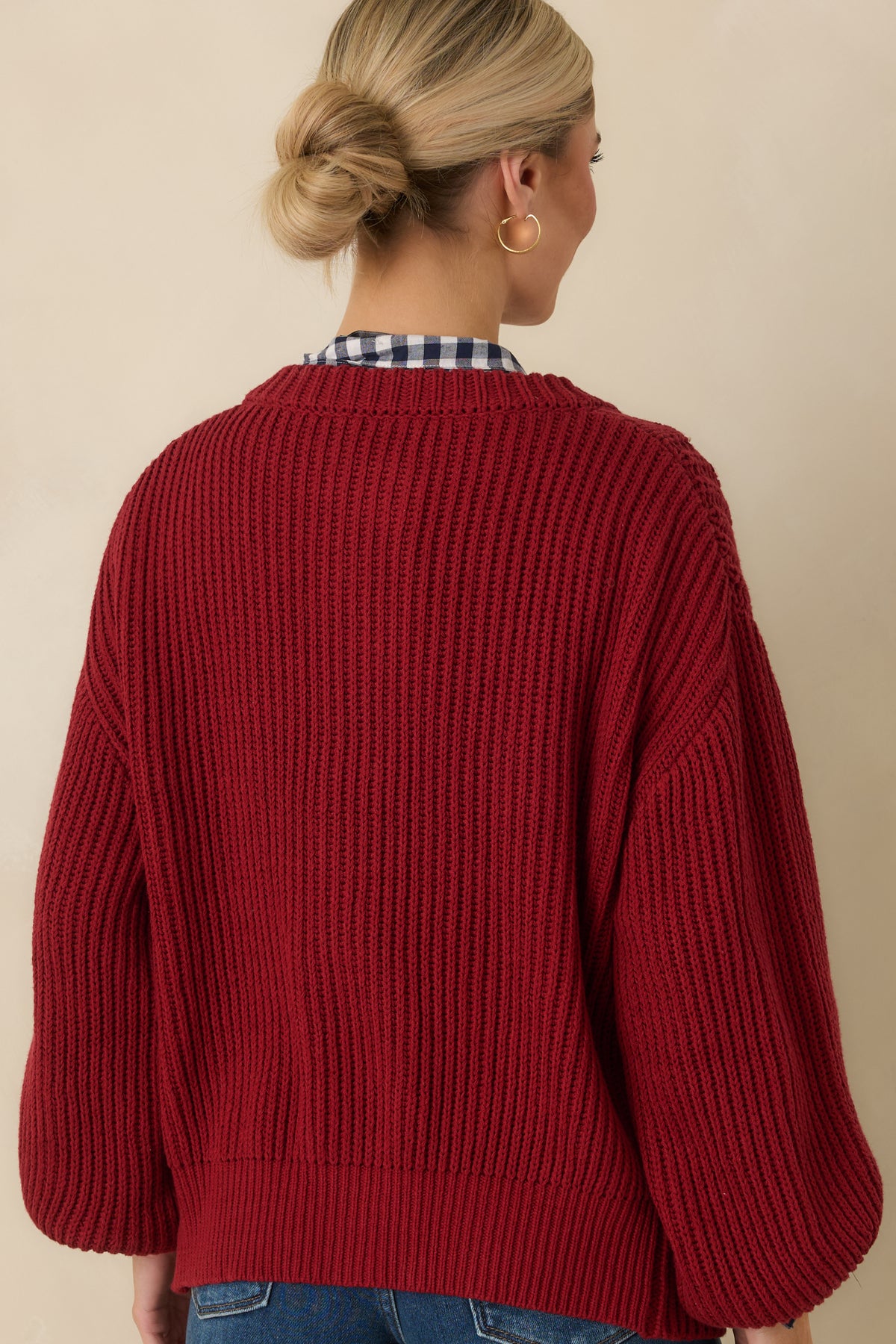 Burgundy cardigan showing the ribbed knit texture across the rear, long sleeves, and relaxed silhouette.