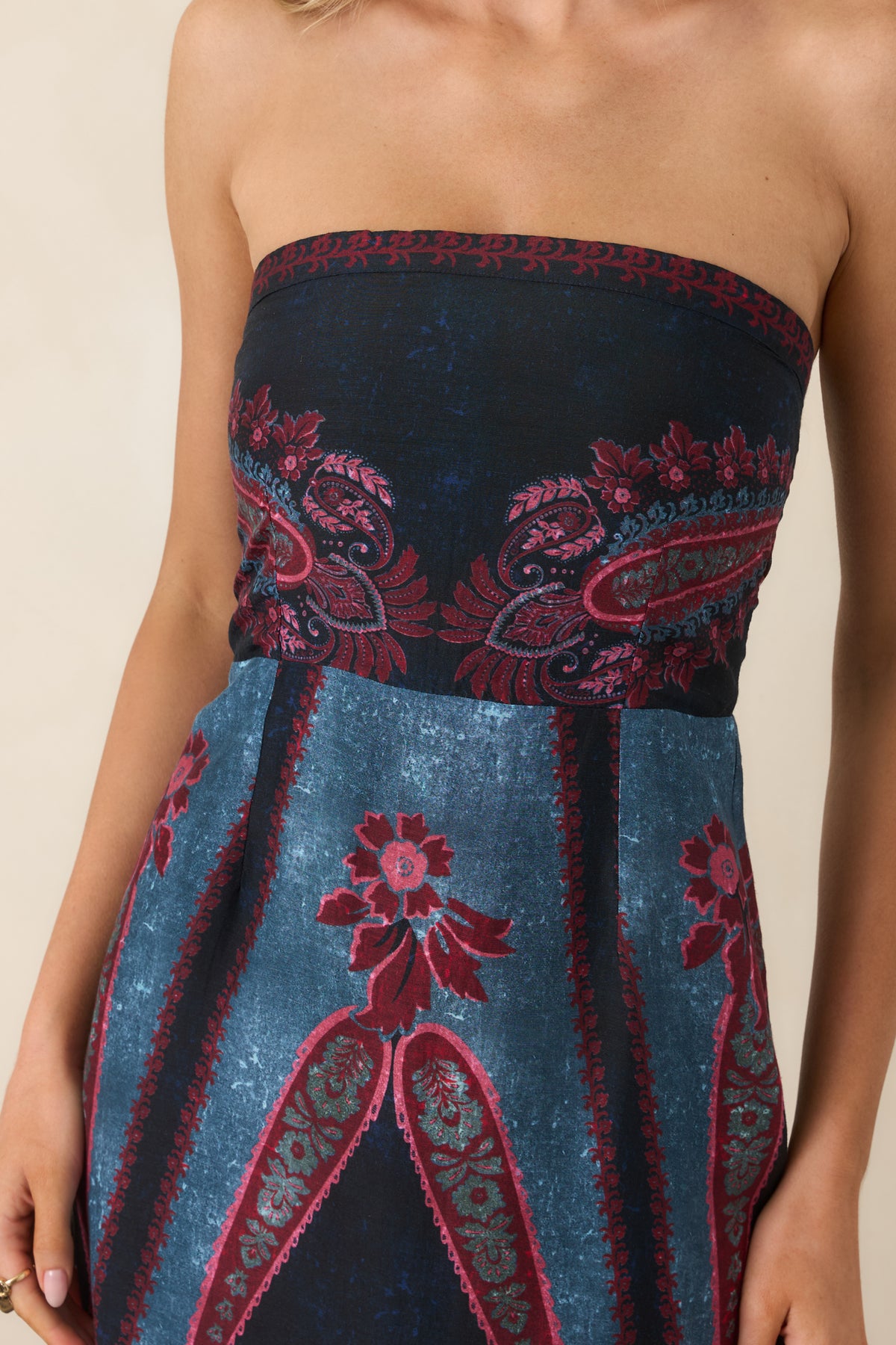 Close-up of the ornate burgundy and rose paisley floral print alongside deep navy and teal blue panel detailing.