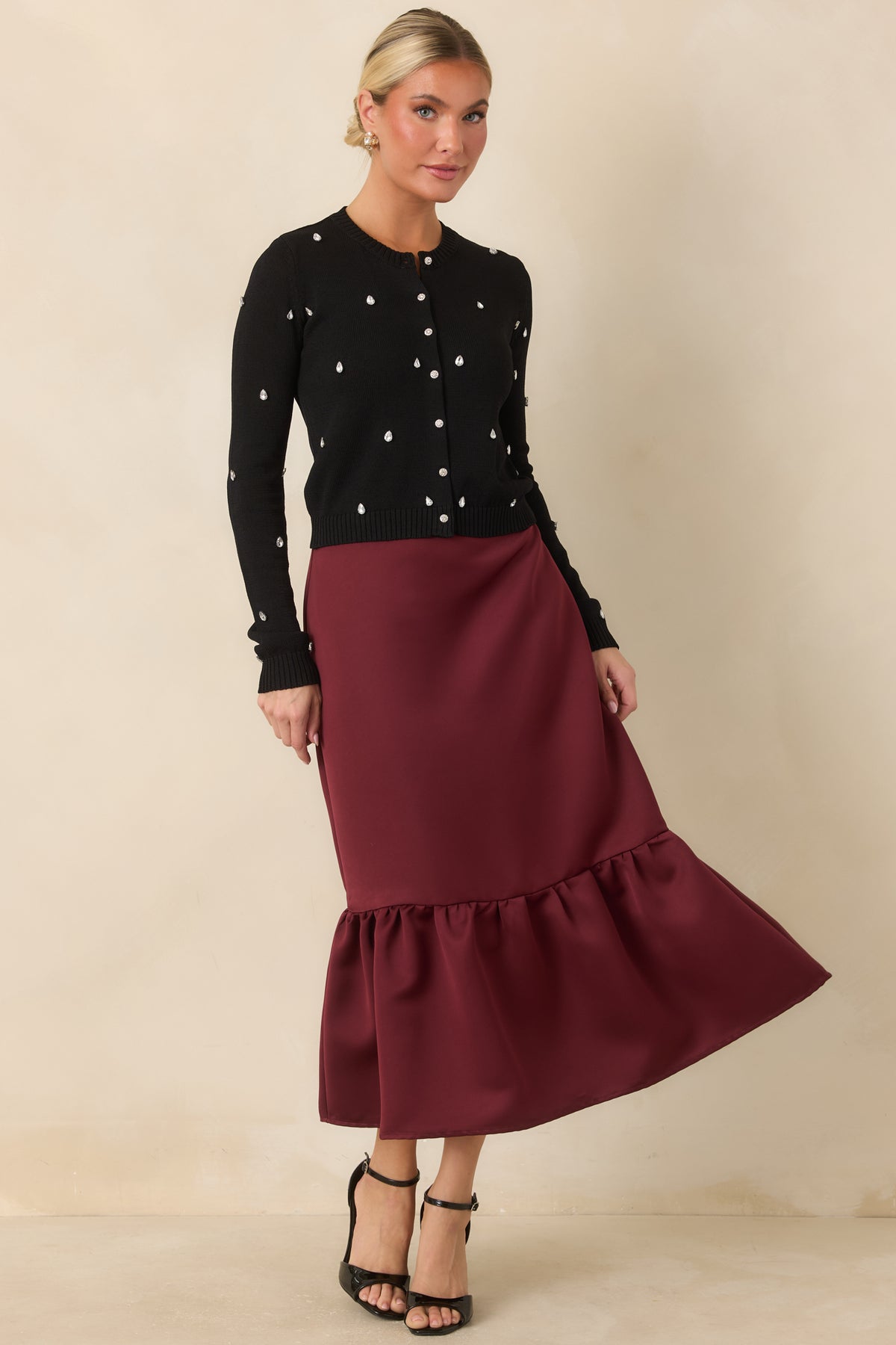 Burgundy satin midi skirt with a smooth fitted silhouette and softly flared gathered hem.