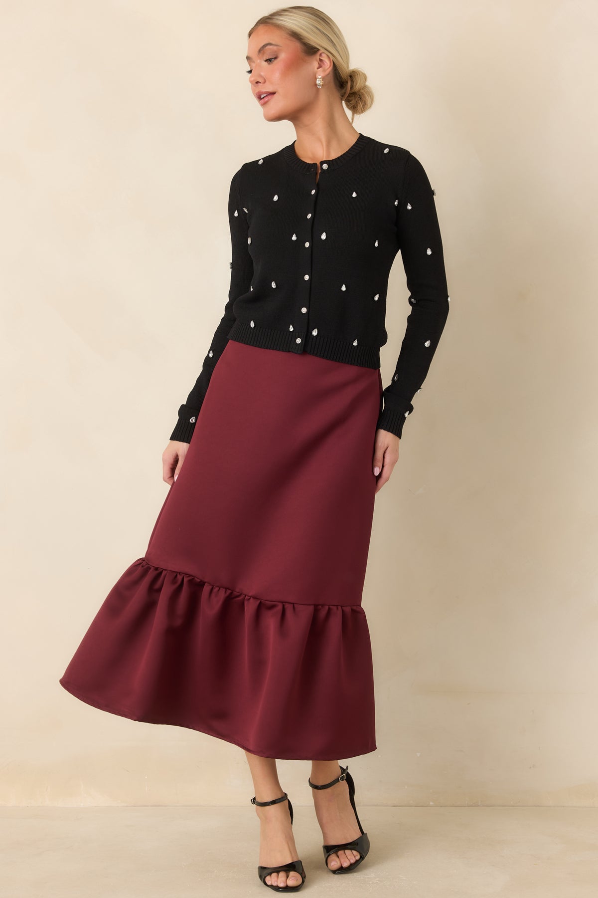 Burgundy satin skirt with a streamlined fitted shape and feminine flounce hem.