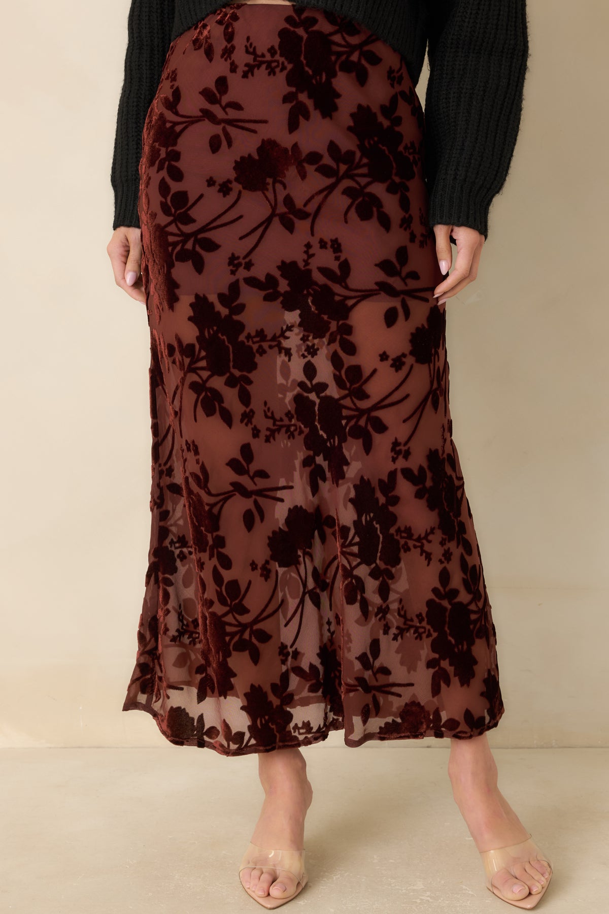 Sheer mesh and textured velvet flowers define the burgundy skirt’s bias-inspired shape and smooth drape.