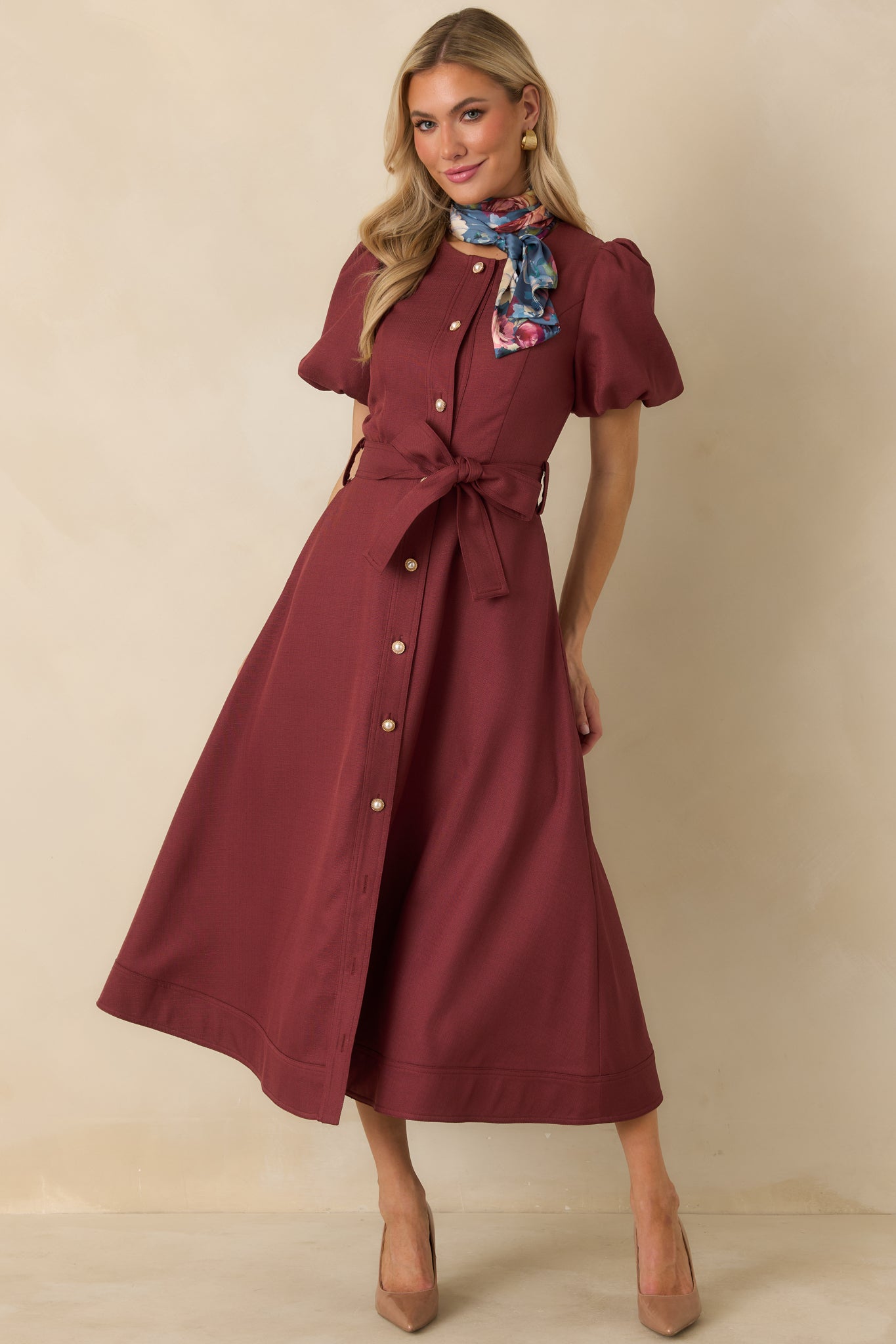 Burgundy woven midi dress with a subtle textured finish, fitted bodice, puff sleeves, pearl buttons, and removable belt.