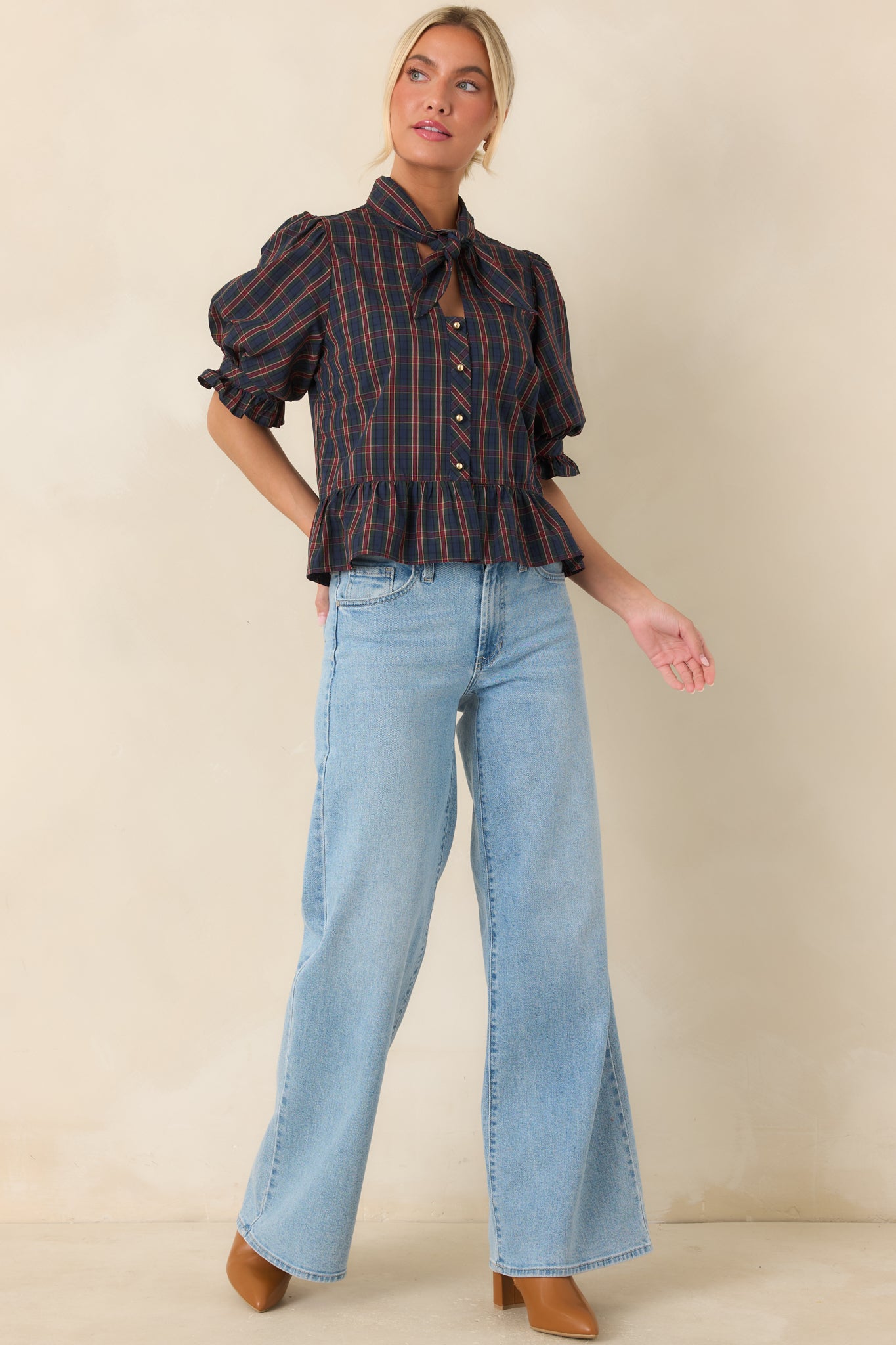 Button-front blouse featuring voluminous sleeves, a fitted bodice, and a softly gathered peplum shape.